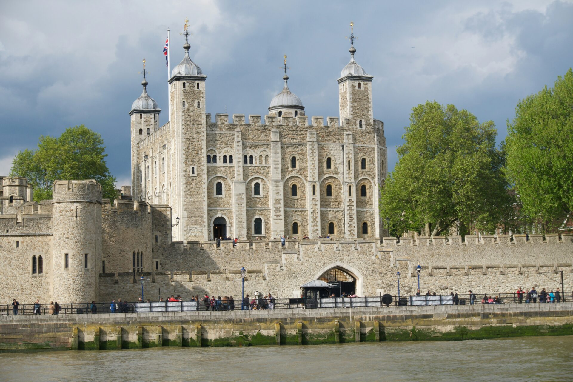 Tower of London fortress with stone walls and White Tower by the River Thames.