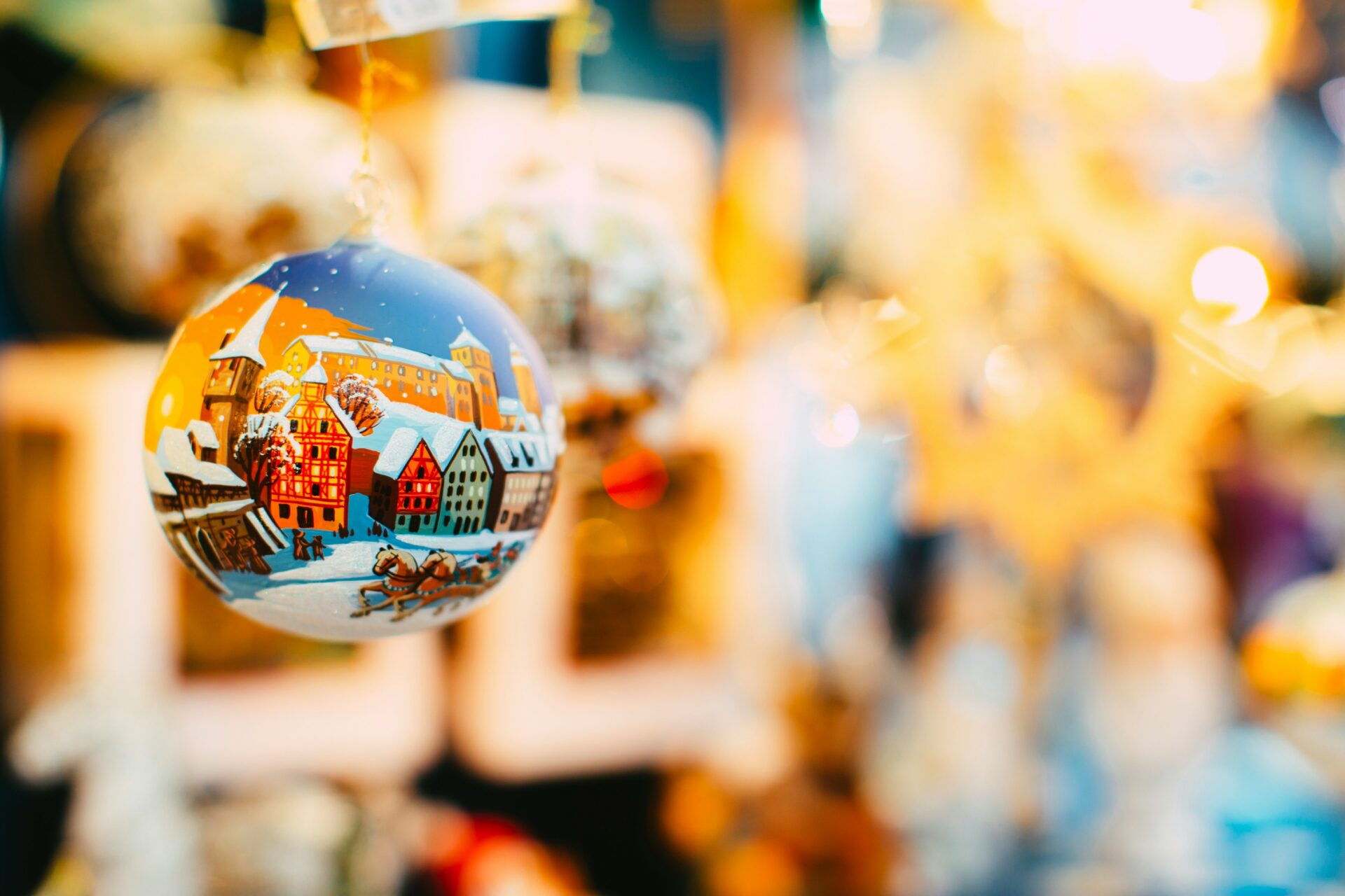 Hand-blown, handcrafted Christmas baubles hanging on display at a festive market stall