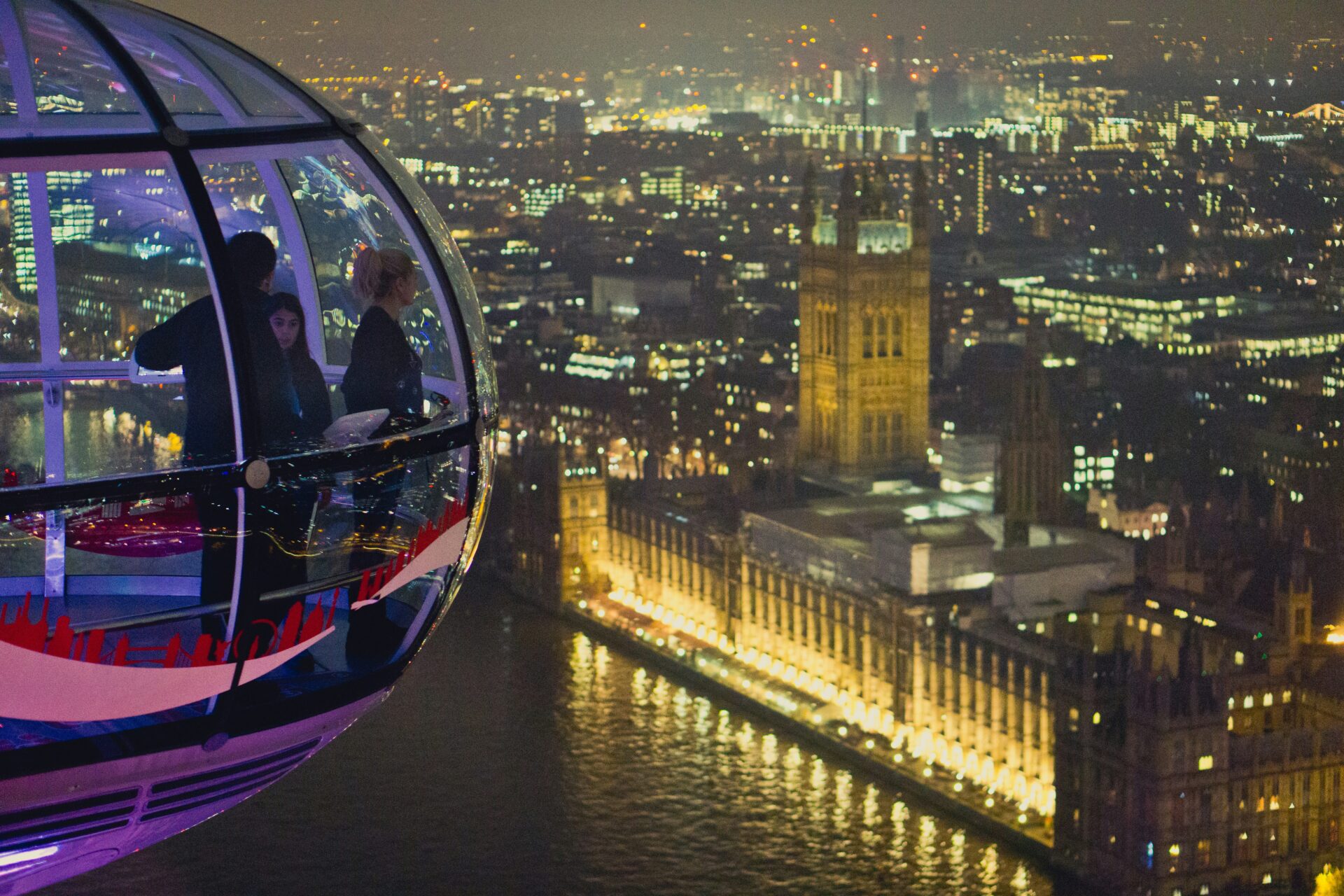 Tourists inside a glass capsule of the London Eye, enjoying panoramic views of London’s skyline