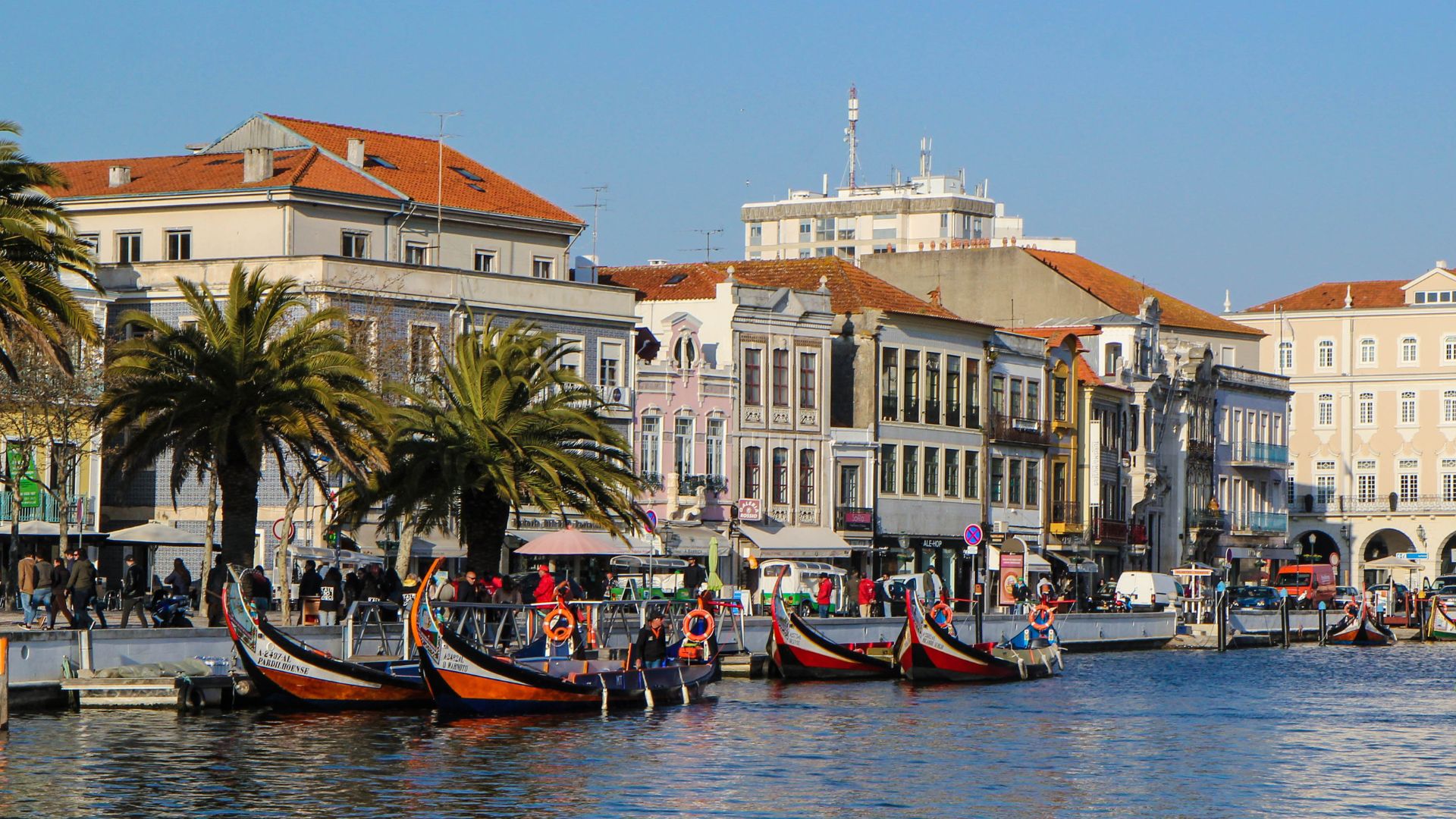 The image showcases the picturesque canals of Aveiro, Portugal, often referred to as the "Venice of Portugal" due to its waterways and colorful moliceiro boats, which are traditionally used for harvesting seaweed.