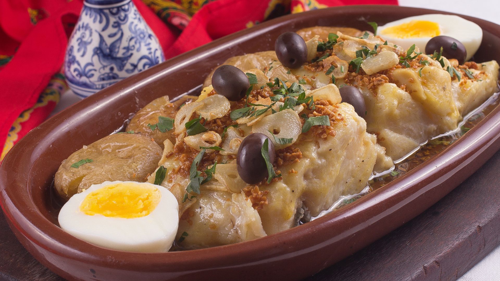 Oven-roasted cod with olive oil and potatoes.