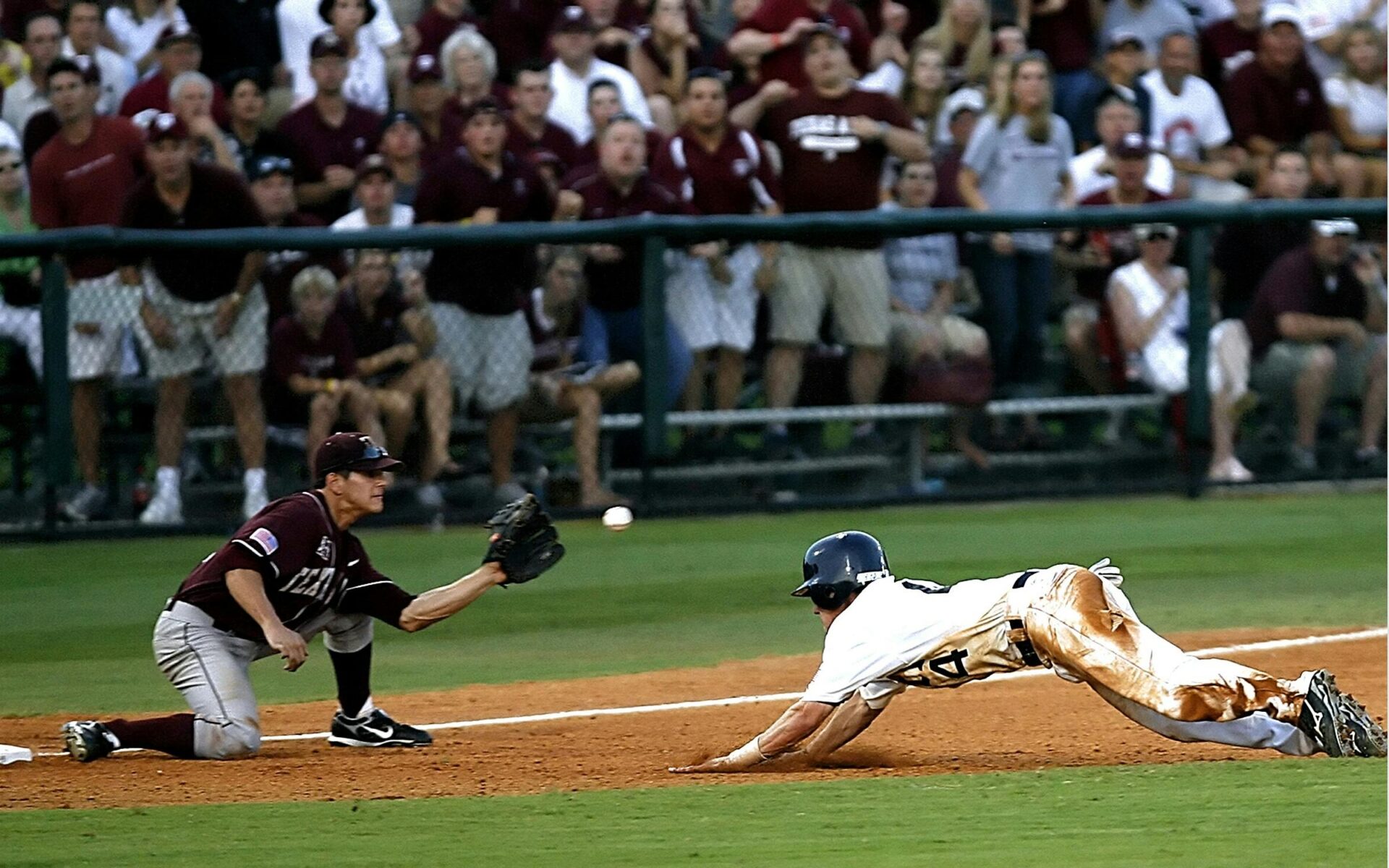 Baseball player mid-swing at the plate, wearing a helmet and uniform during a daytime game