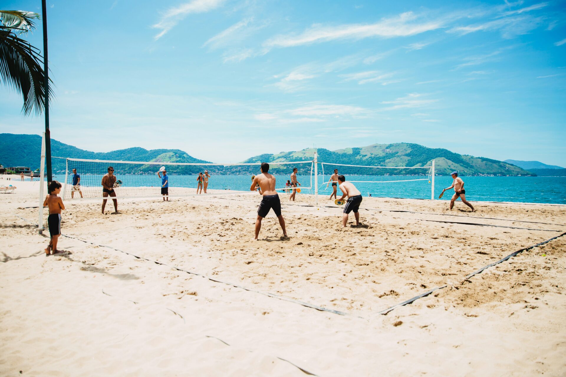 People playing beach volleyball on the sandy courts of Miami Beach