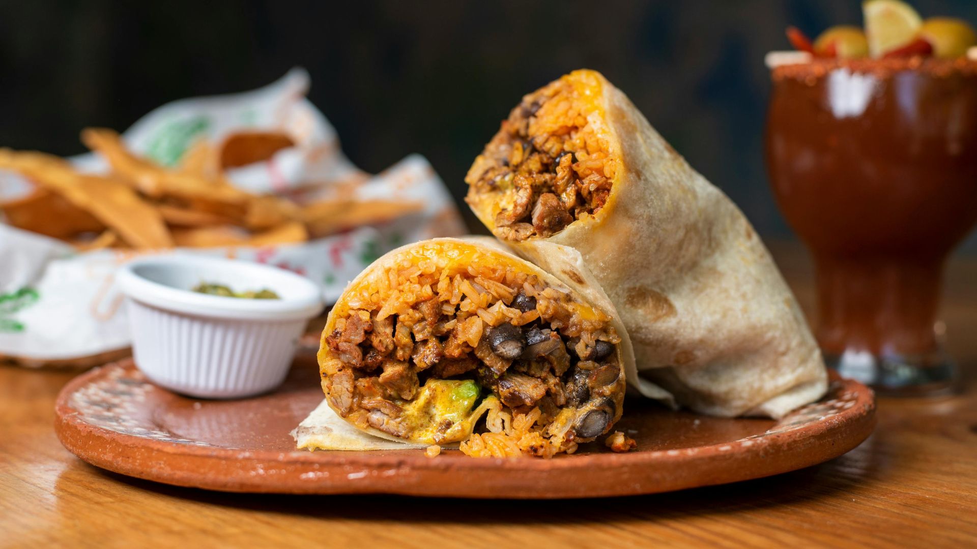 The image shows a burrito that appears to contain meat (likely carne asada), rice, and possibly beans or other fillings.