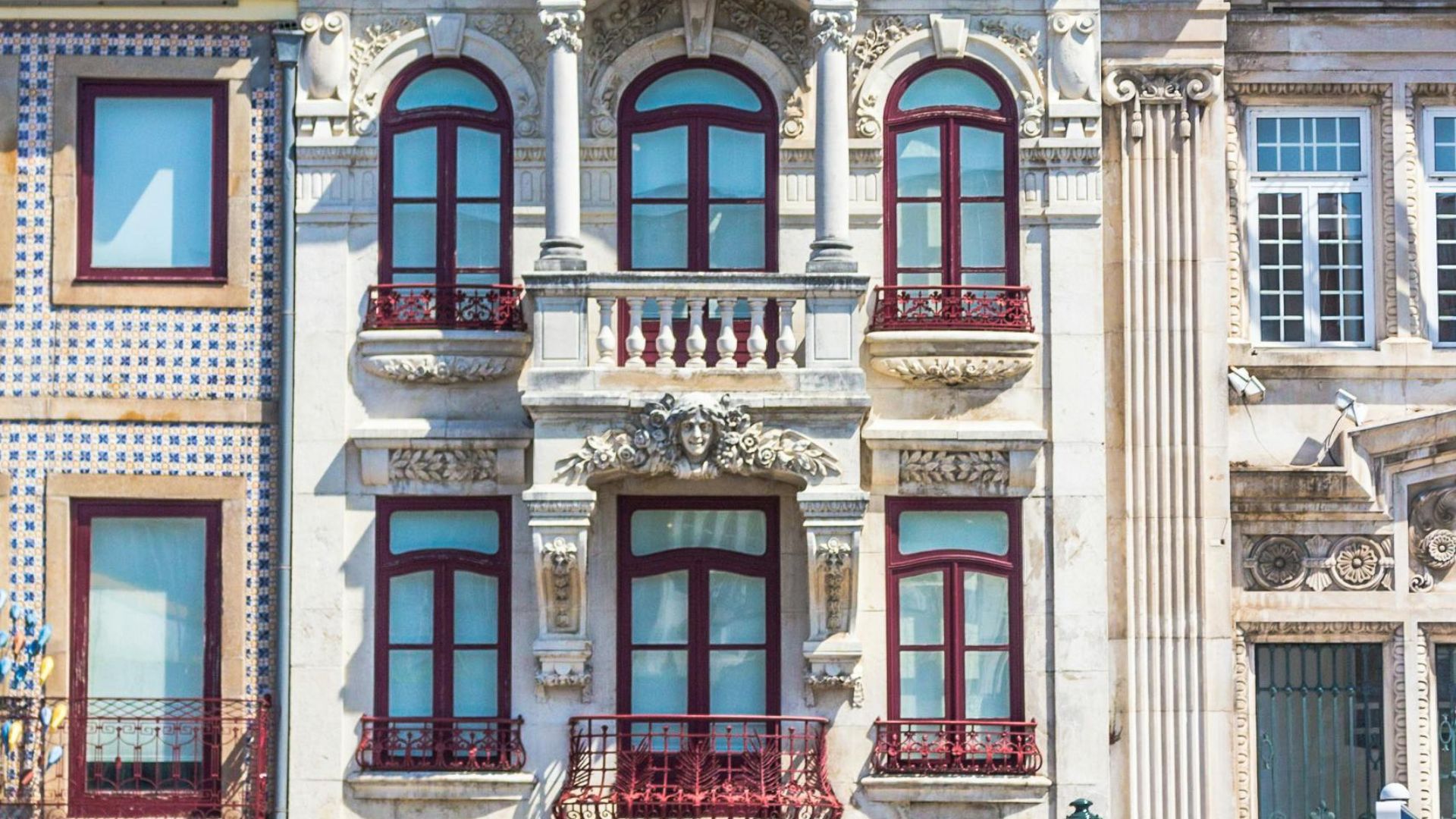 A vibrant Art Nouveau building facade in Aveiro, Portugal, featuring intricate details, curved lines, and decorative elements.