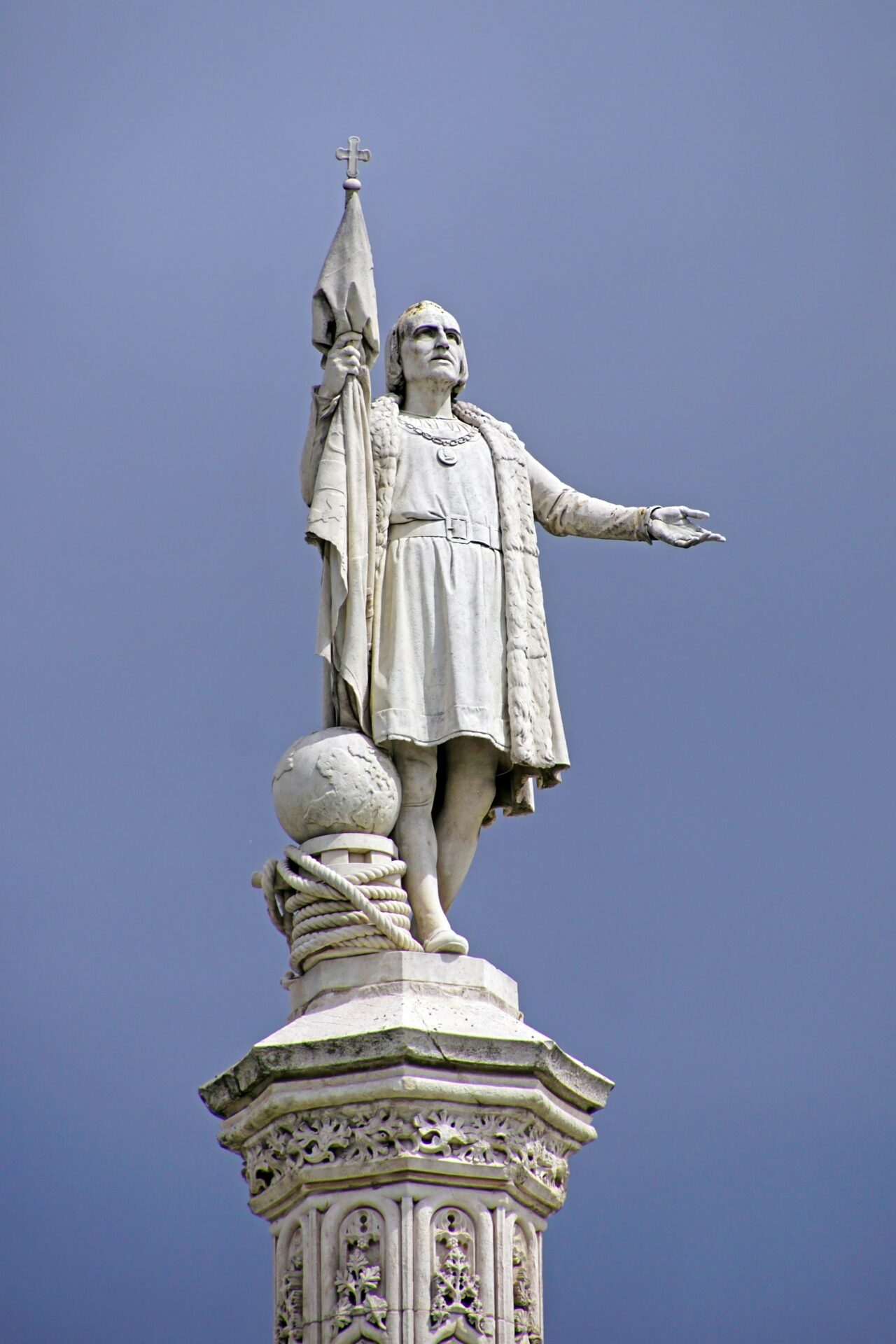 Bronze statue of Christopher Columbus standing with one arm outstretched, gazing toward the horizon
