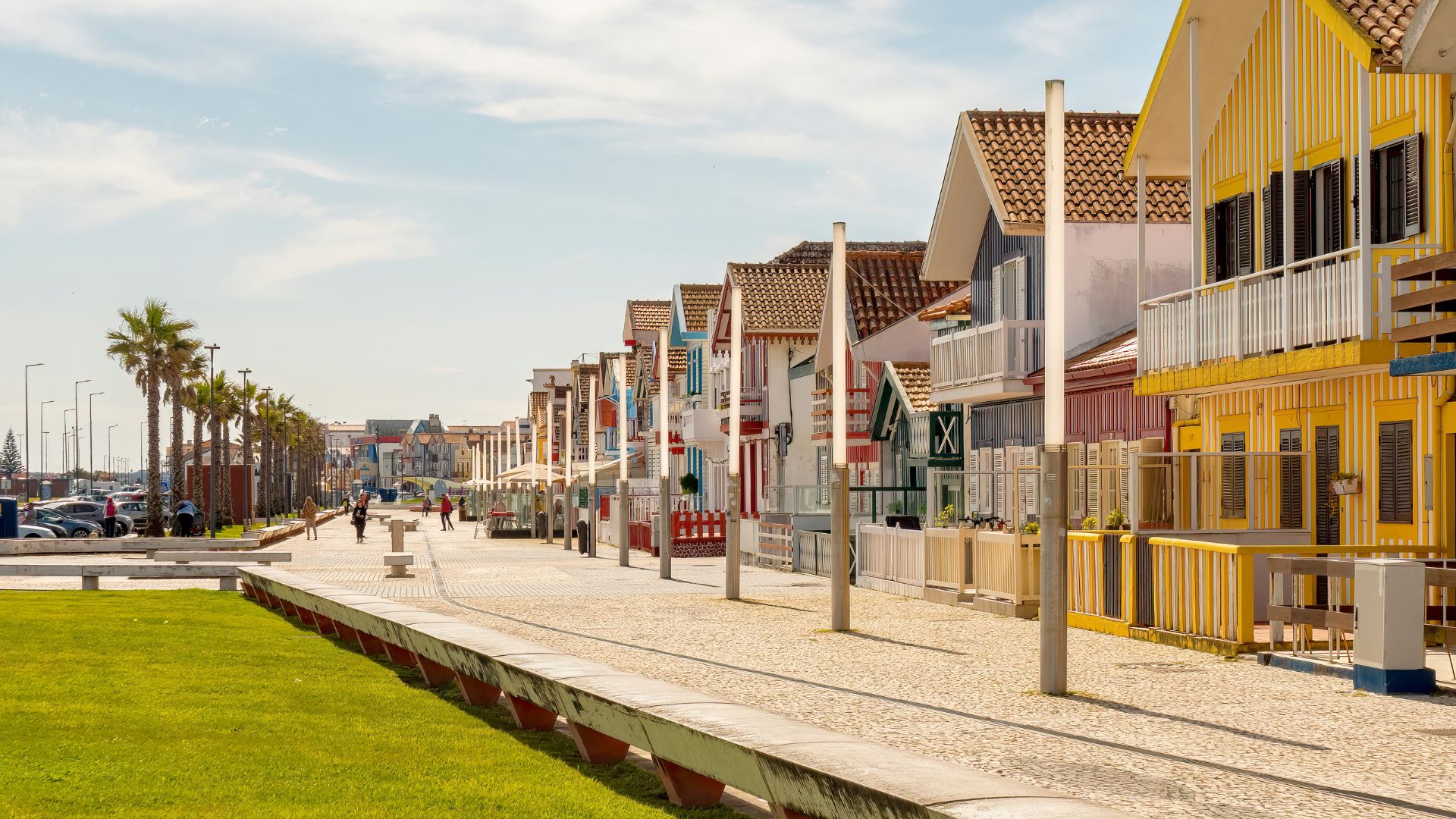 This image showcases the iconic striped houses, known as palheiros, that line the promenade of Costa Nova beach in Portugal. These colorful former fishermen's warehouses are a defining feature of this popular coastal village, known for its unique architecture and proximity to the Atlantic Ocean. 