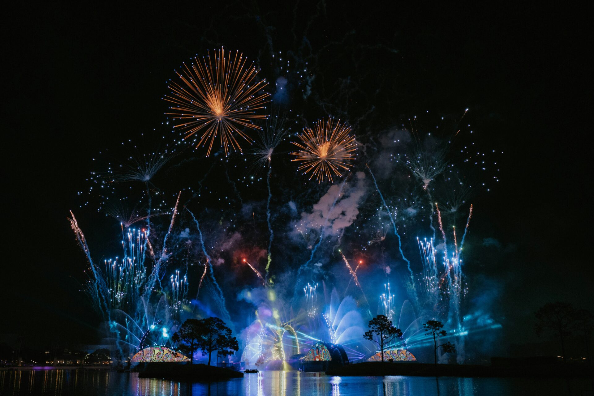  Festive fireworks bursting in red, green, and gold colors against a night sky during a Christmastime celebration in Orlando