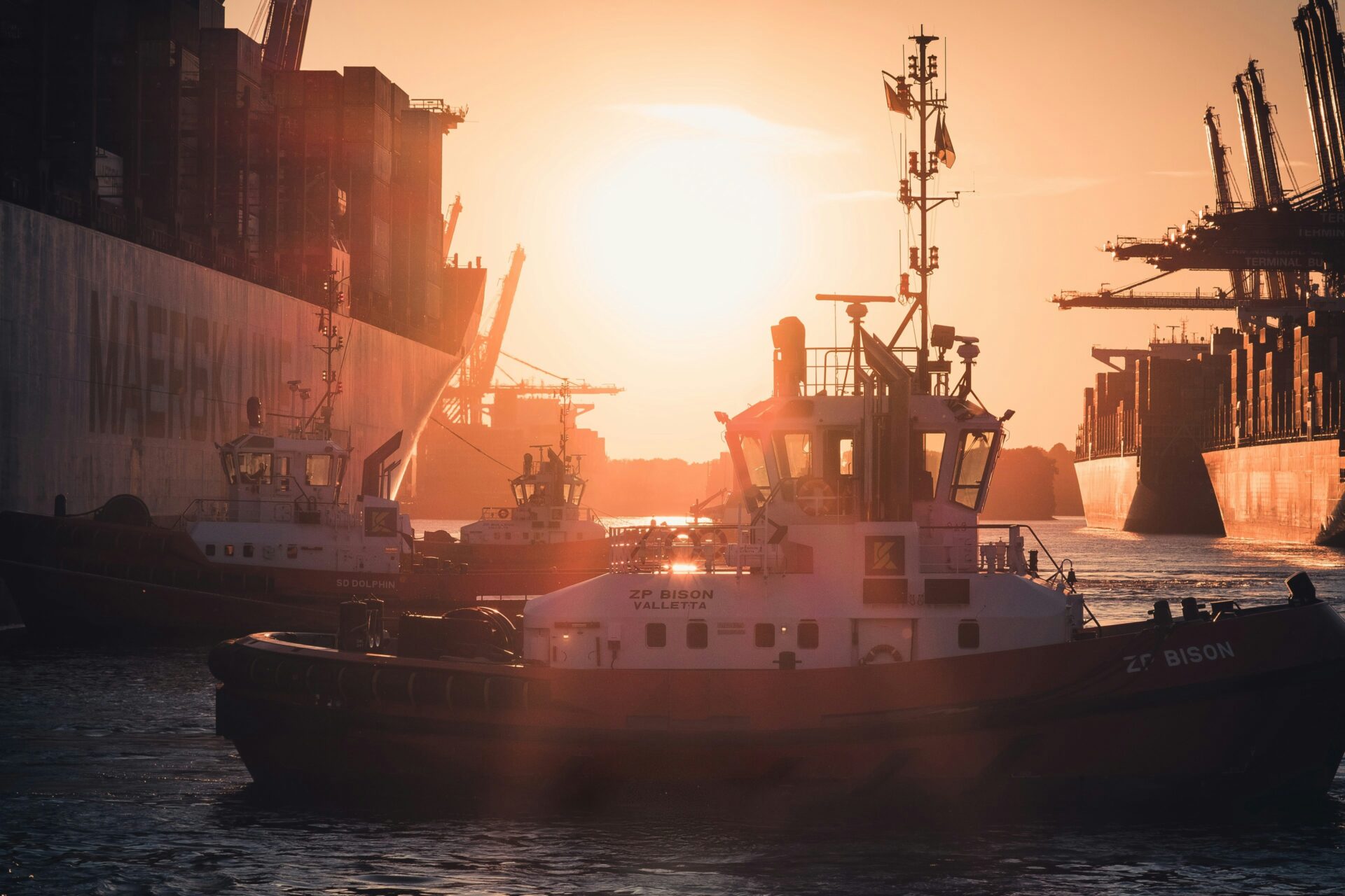 Sunset over the North Sea with a fishing boat silhouetted against golden waters near Hamburg.