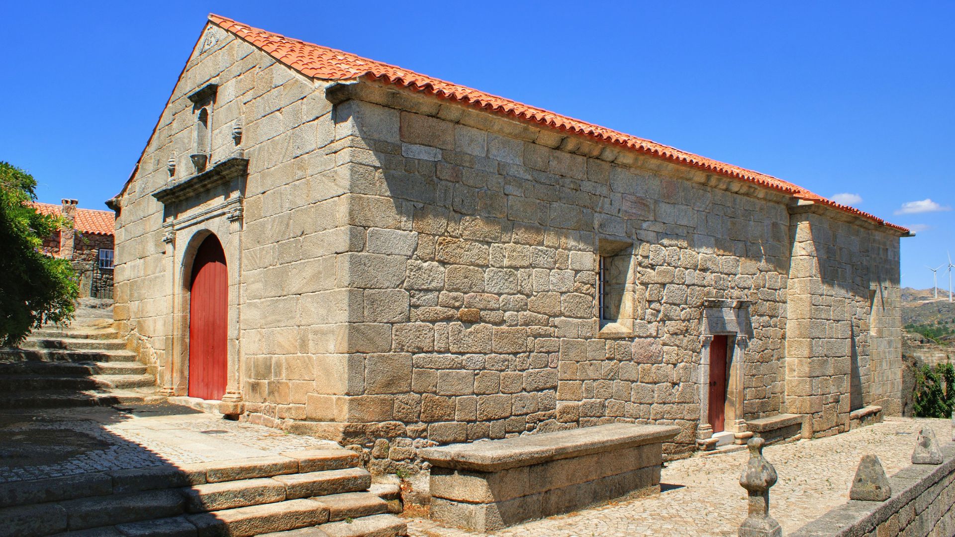 The image depicts the Main Parish Church (Igreja Matriz), dedicated to Our Lady of the Snows, located within the walled perimeter of Sortelha, Portugal. 