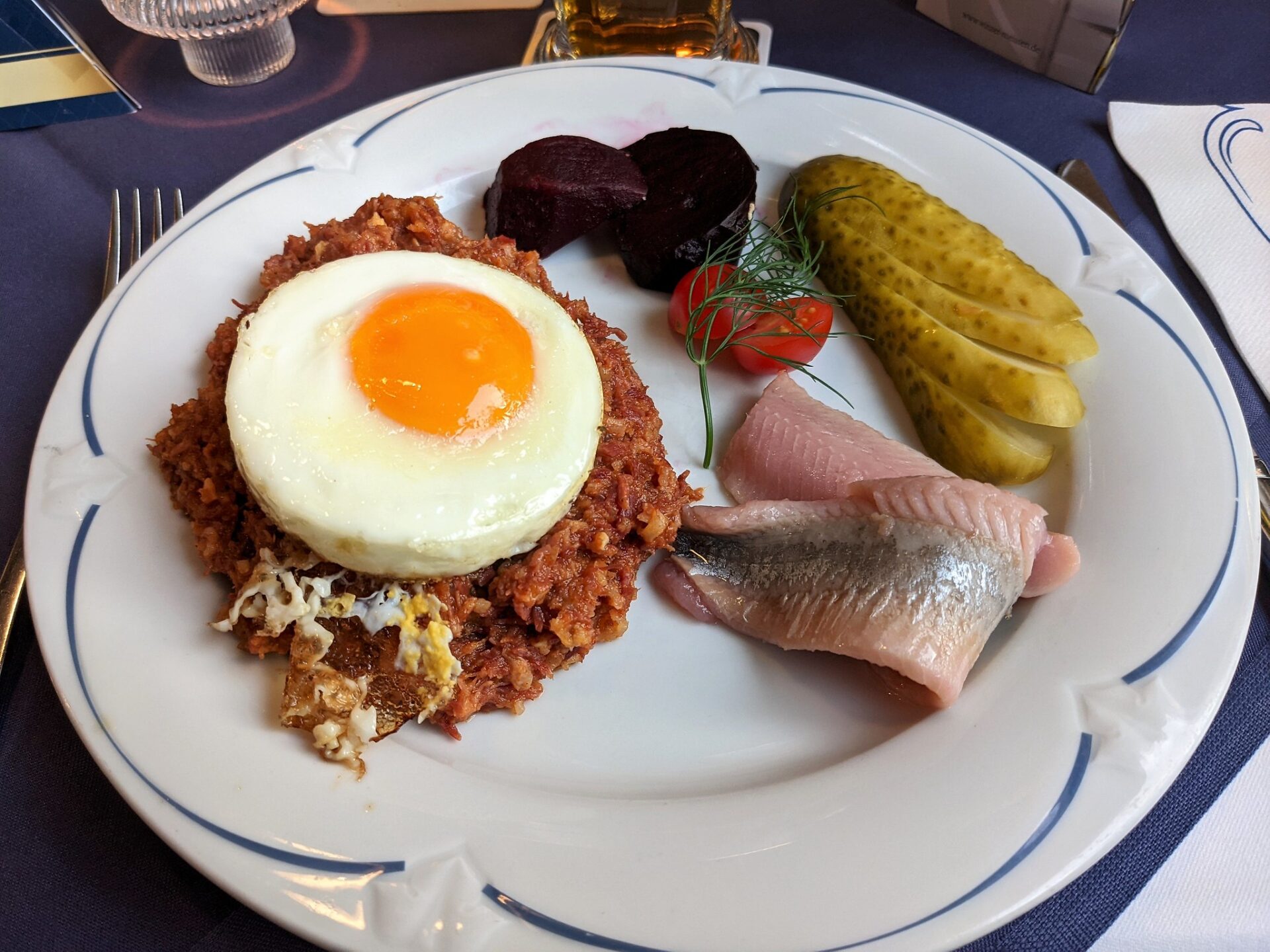 Close-up of Labskaus, a pinkish mashed dish with beetroot, potato, and corned beef, topped with a sunny-side-up egg