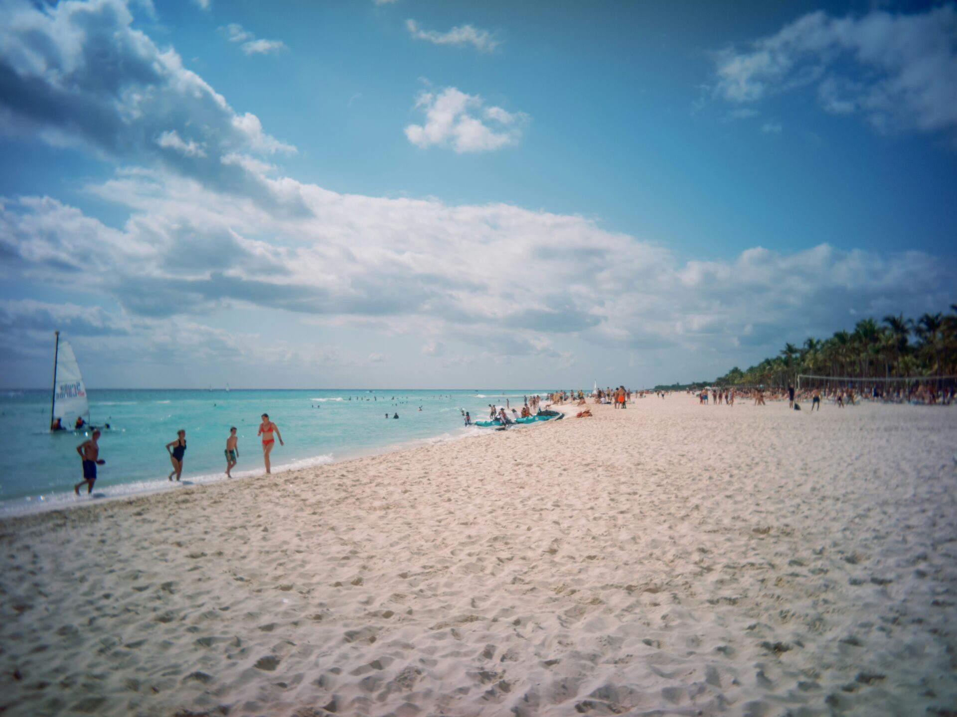 A vibrant crowd of people enjoying the sun and ocean at Miami Beach