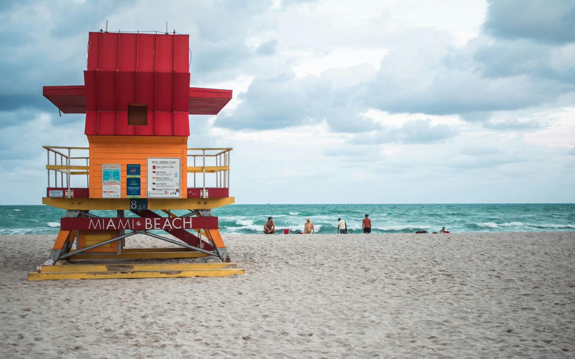 A bright red lifeguard tower on the white sands of Miami Beach