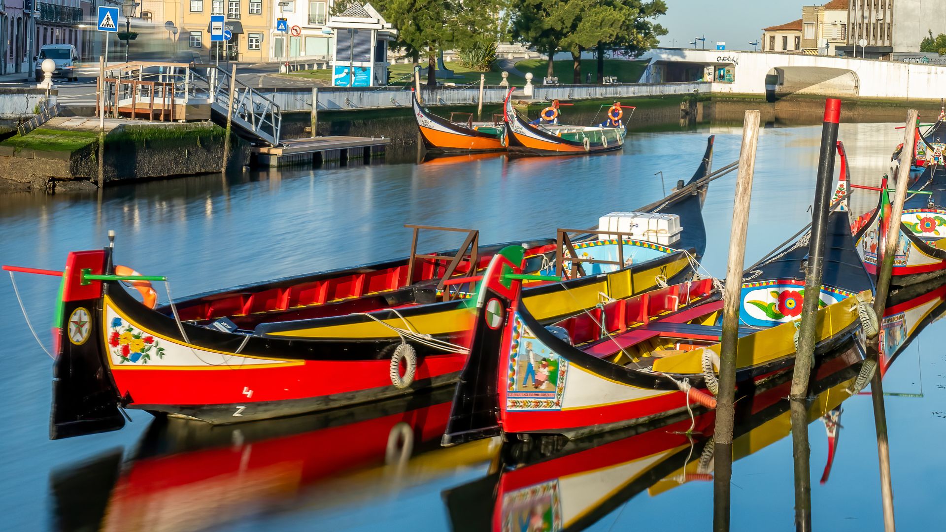 This image showcases the vibrant Moliceiros boats on the canals of Aveiro, often referred to as the "Venice of Portugal" due to its picturesque waterways and traditional boats. 