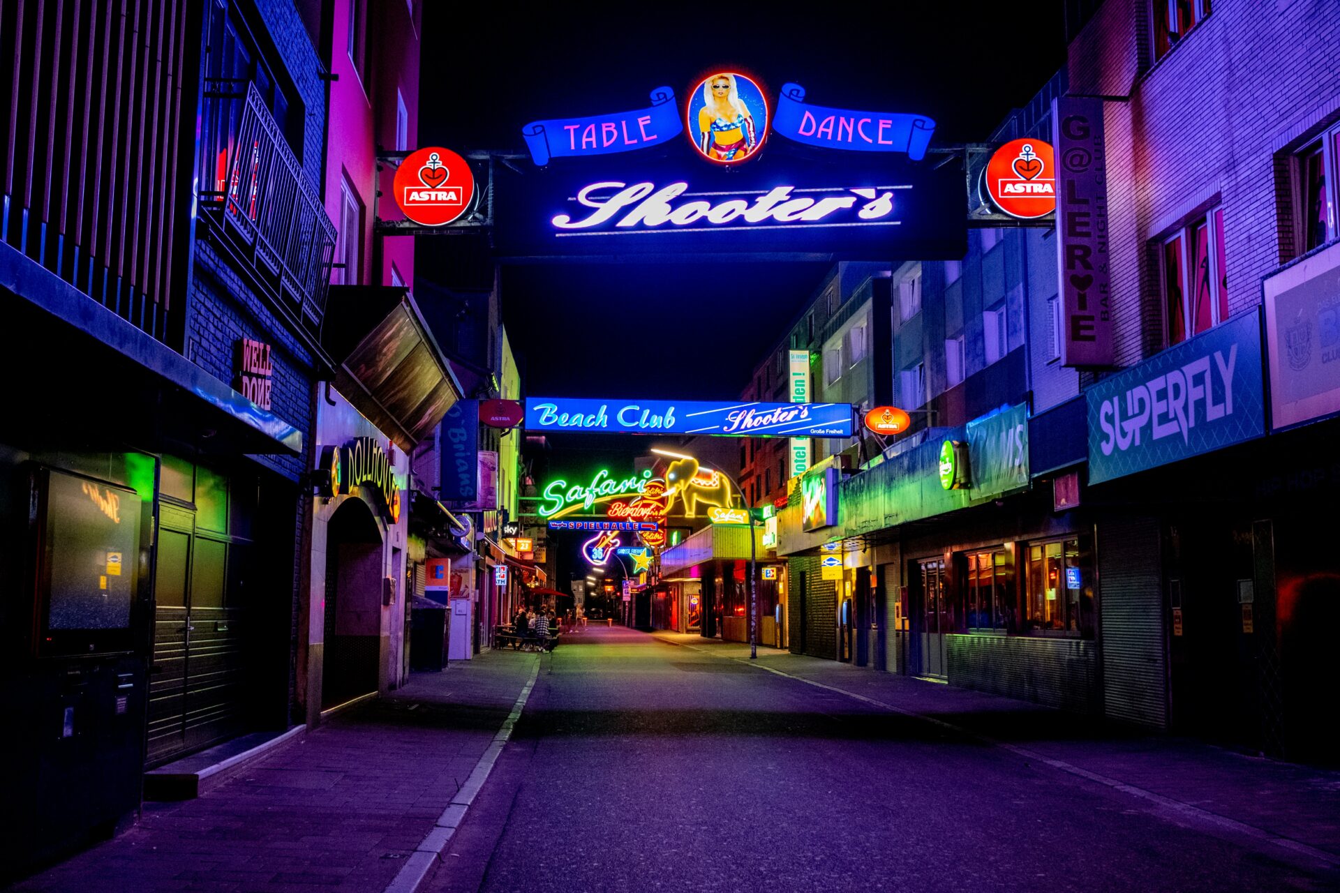 Reeperbahn street at night, bathed in the glow of neon lights and signs