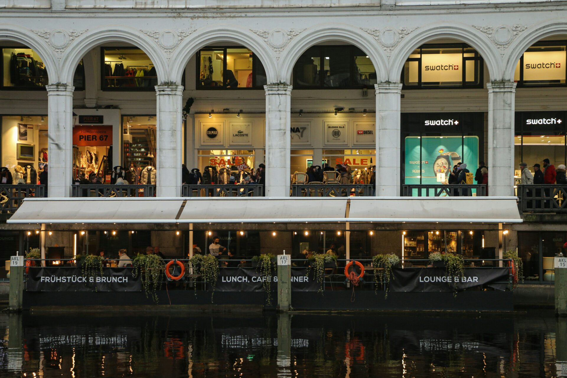 Crowd of diners eating and chatting at a riverside restaurant in Hamburg