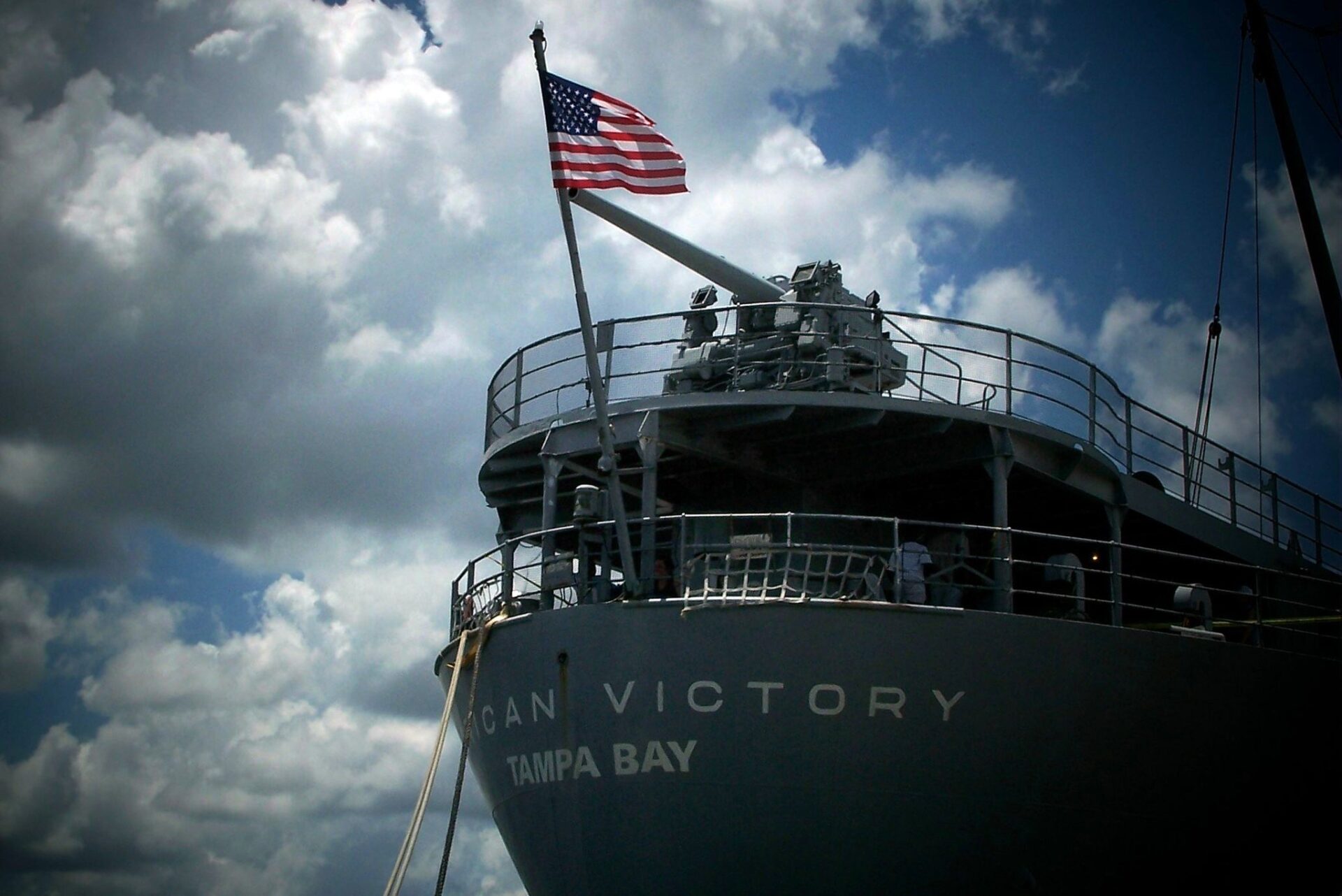 SS American Victory docked in Tampa with the U.S. flag flying during a Memorial Day ceremony.
