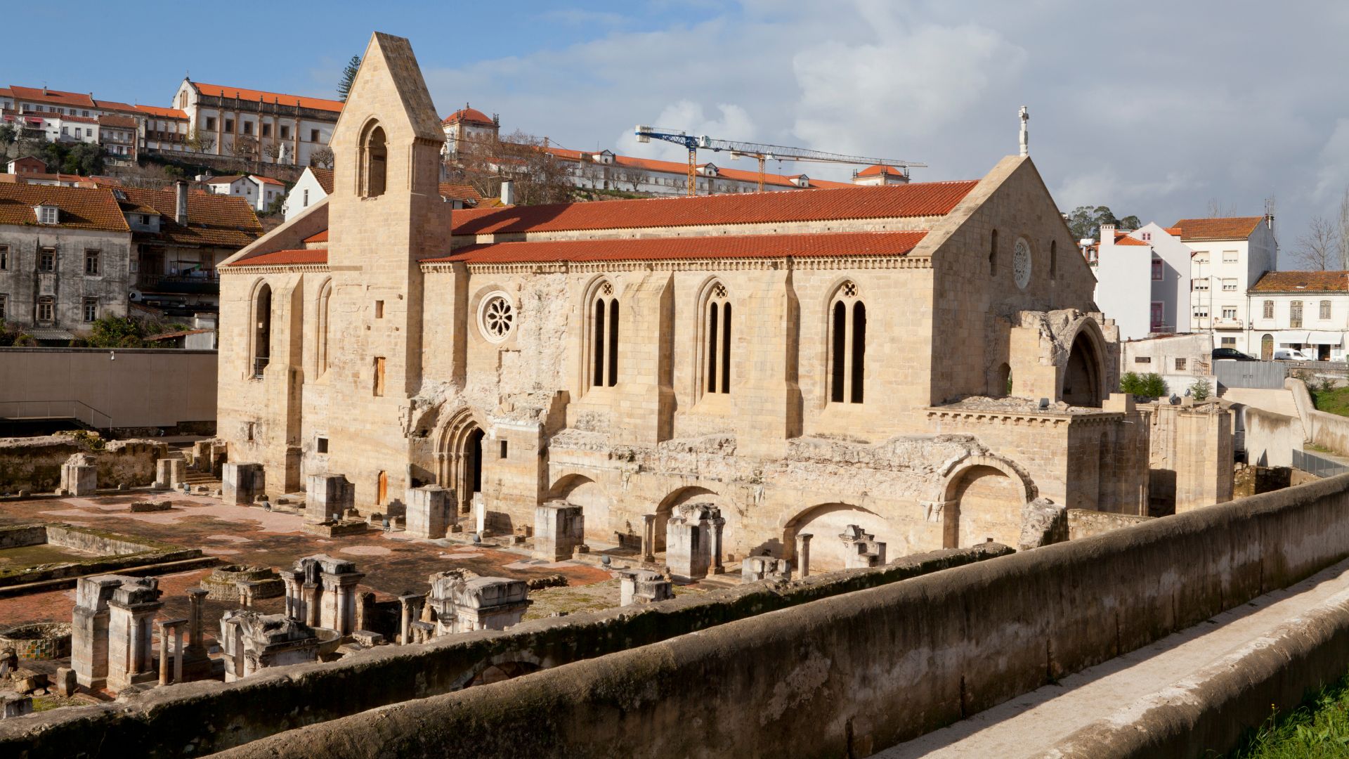The image captures the evocative ruins of the 14th-century Mosteiro de Santa Clara-a-Velha in Coimbra, Portugal, a historic monastery frequently impacted by the Mondego River's floods, leading to its eventual abandonment in the 17th century. 