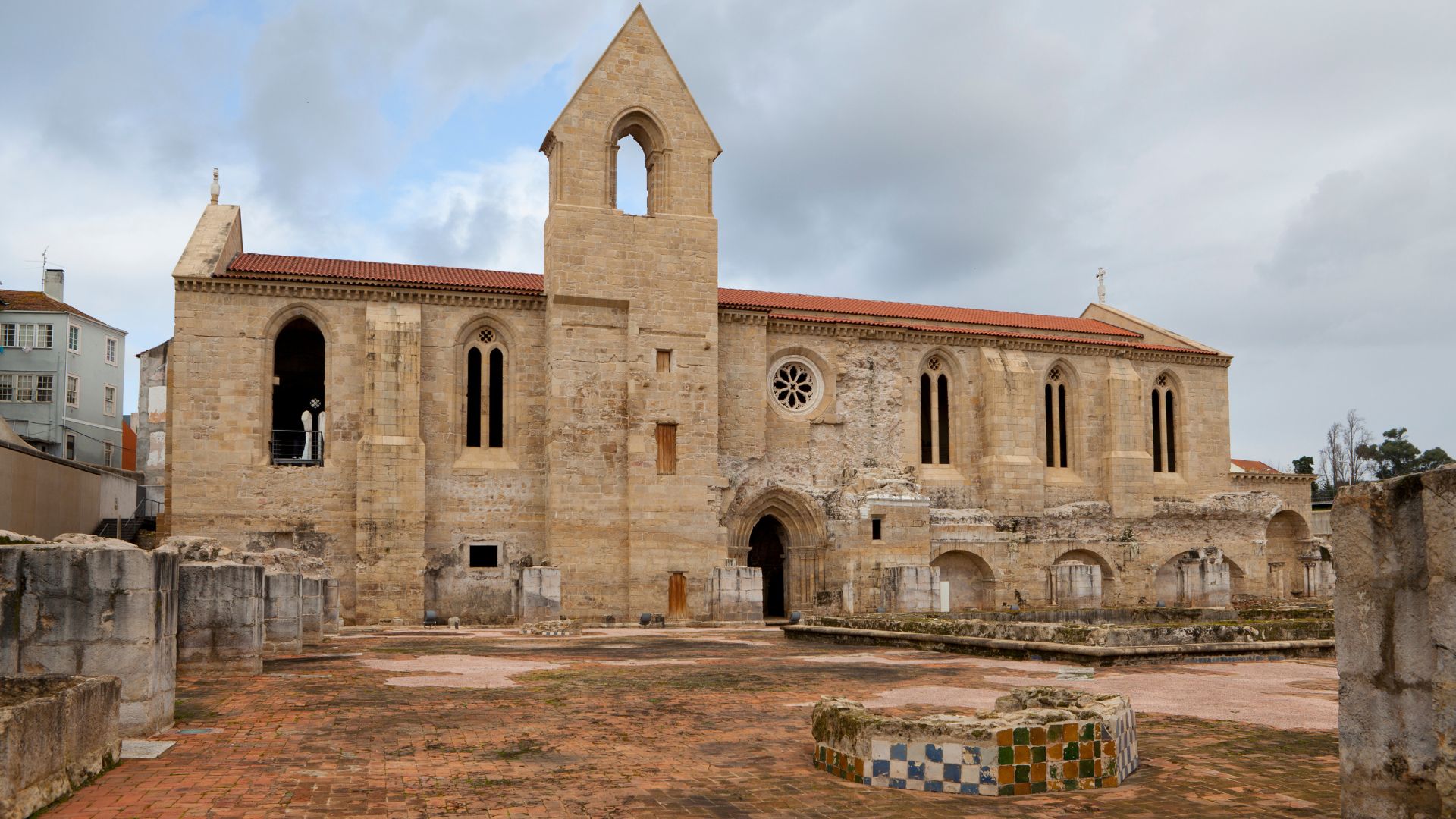 The image captures the evocative ruins of the 14th-century Mosteiro de Santa Clara-a-Velha in Coimbra, Portugal, a historic monastery frequently impacted by the Mondego River's floods, leading to its eventual abandonment in the 17th century. 