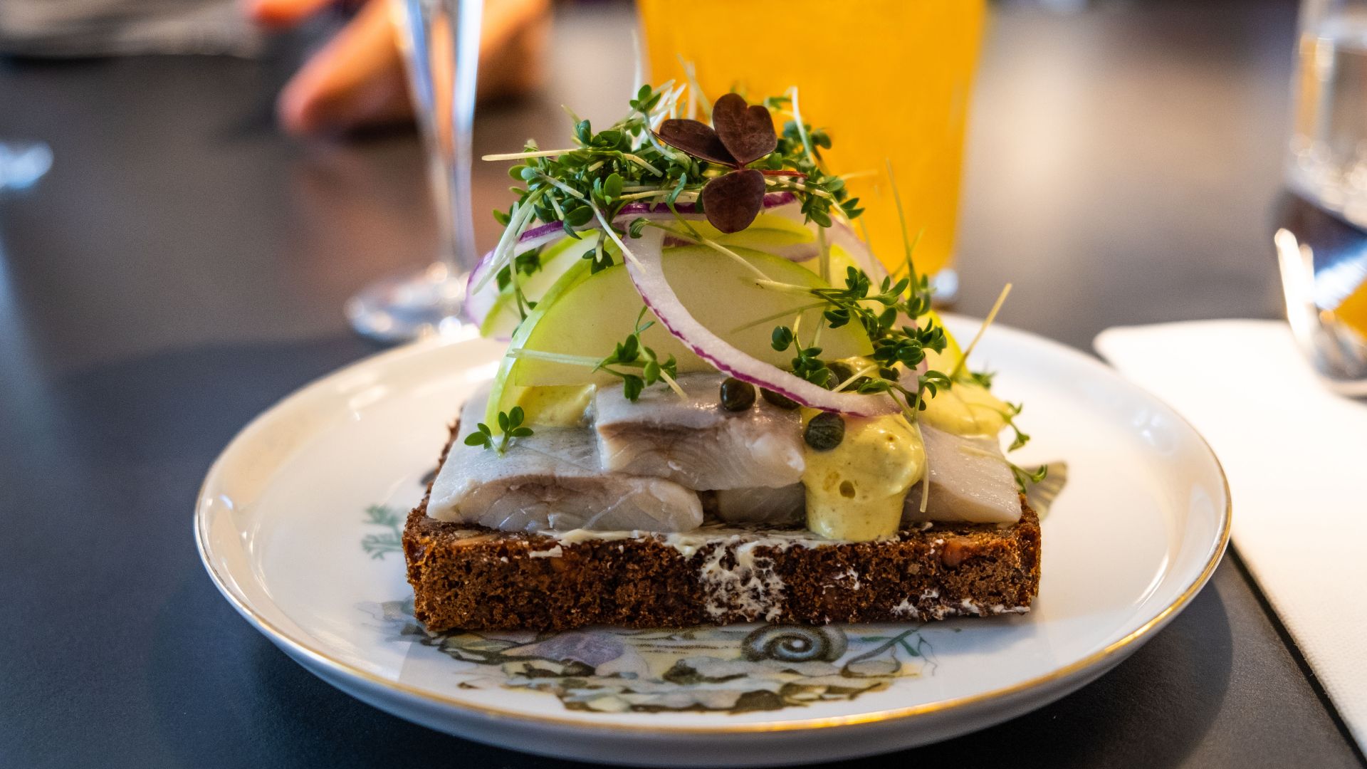 The food shown in the image is Smørrebrød, a traditional Danish open-faced sandwich