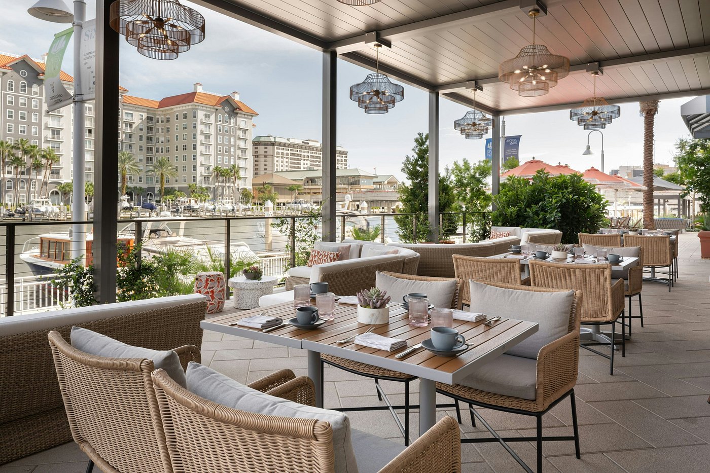 Outdoor café at Tampa Marriott Water Street with tables, umbrellas, and a view of the waterfront.