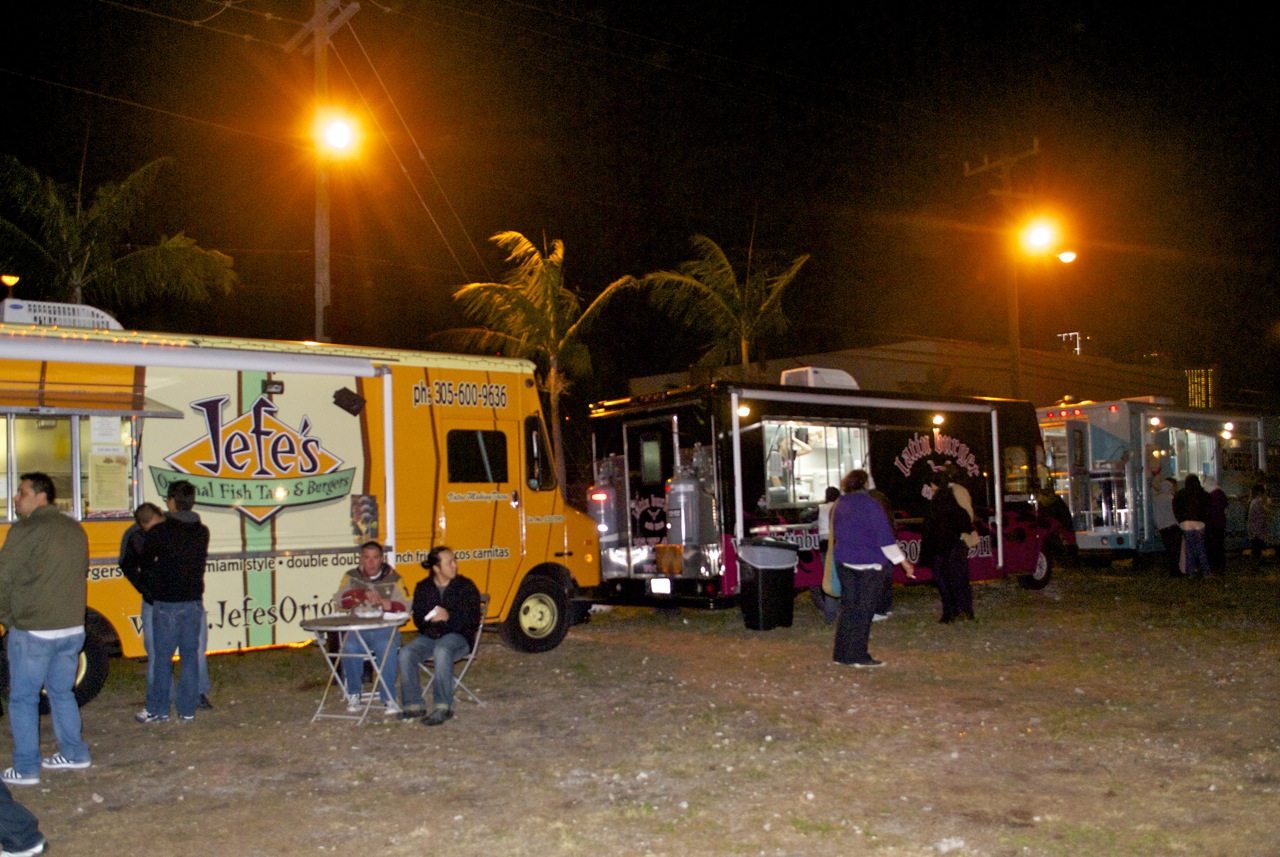 A vibrant food truck parked in the artsy Wynwood district at night