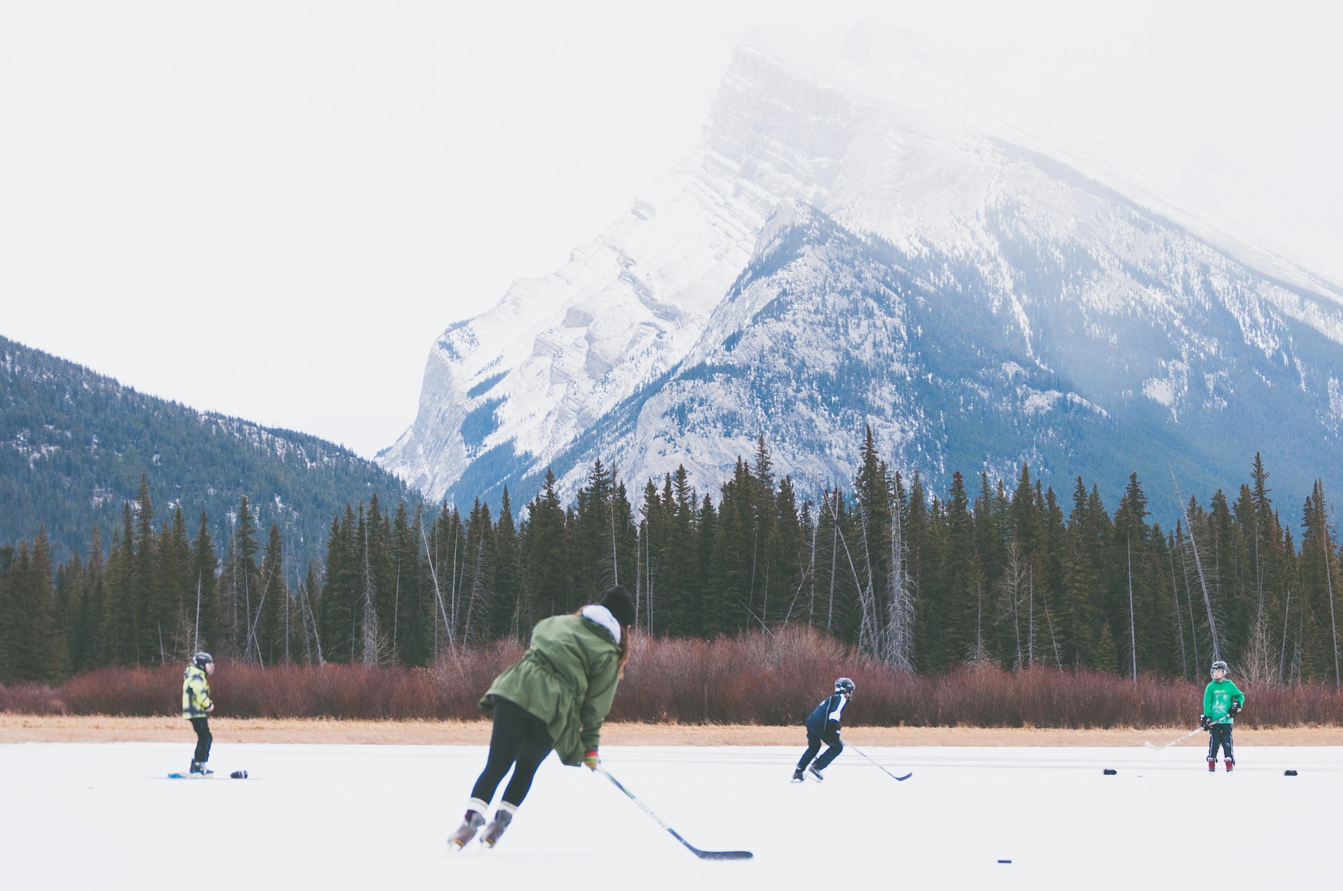 People playing a novelty snow golf game on a frozen lake in Banff National Park