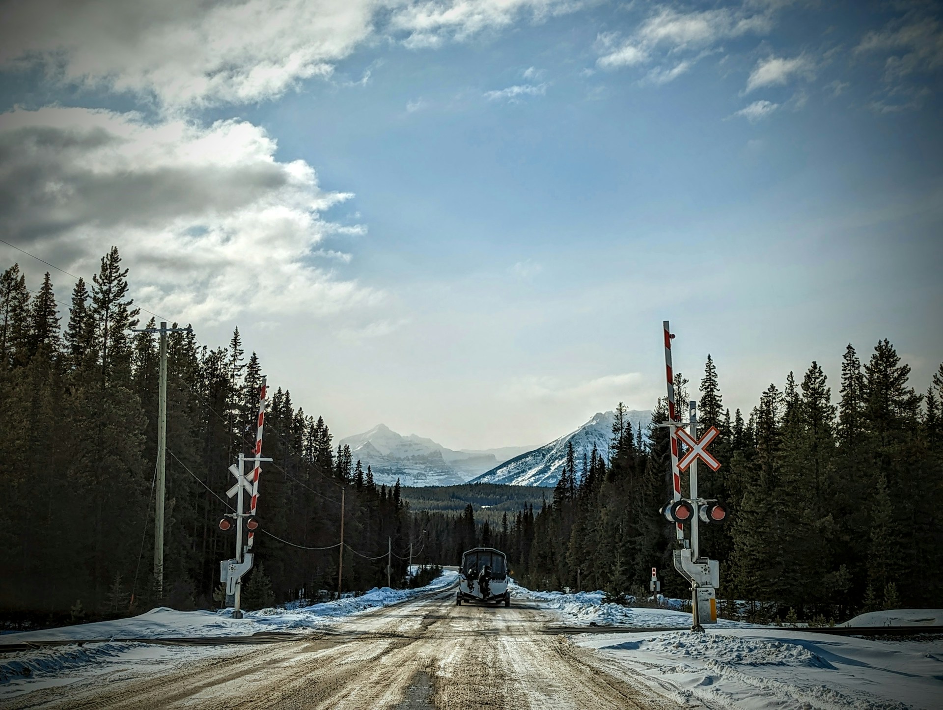 Two-lane road stretching through a scenic Canadian landscape