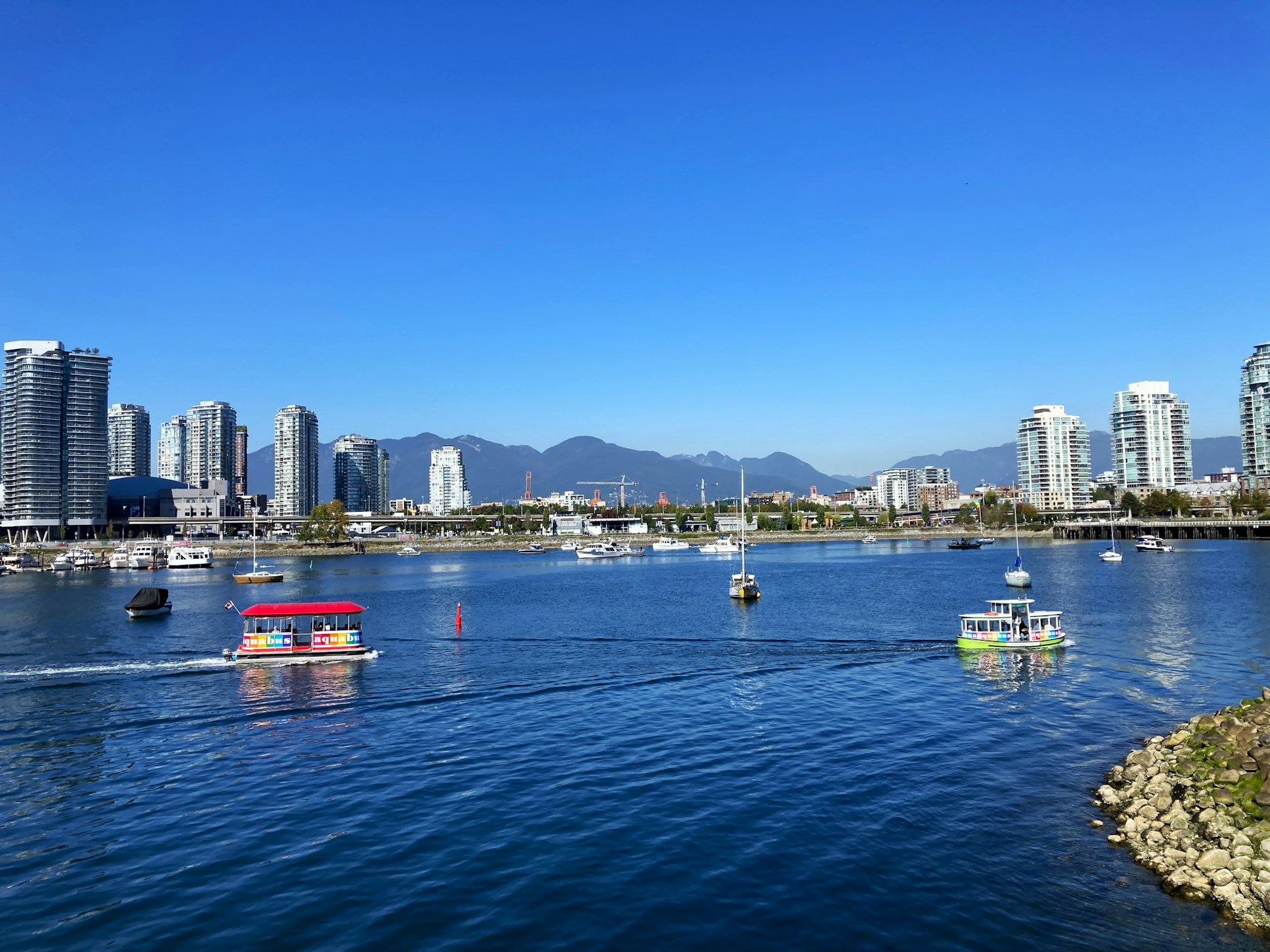 A scenic view of False Creek in Vancouver, showing the skyline and boats on the water.