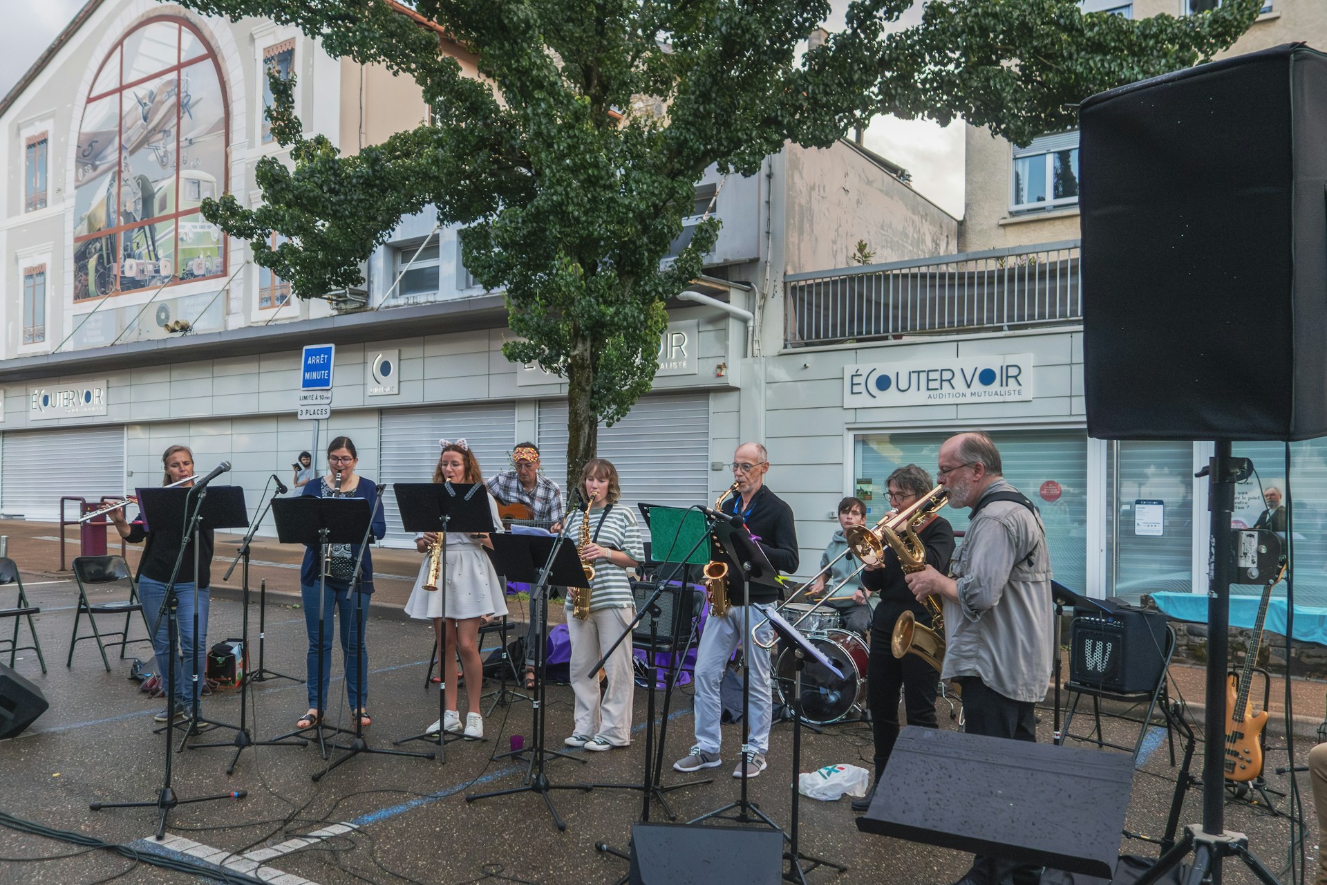  diverse group of musicians performing on an outdoor stage for Fête de la Musique