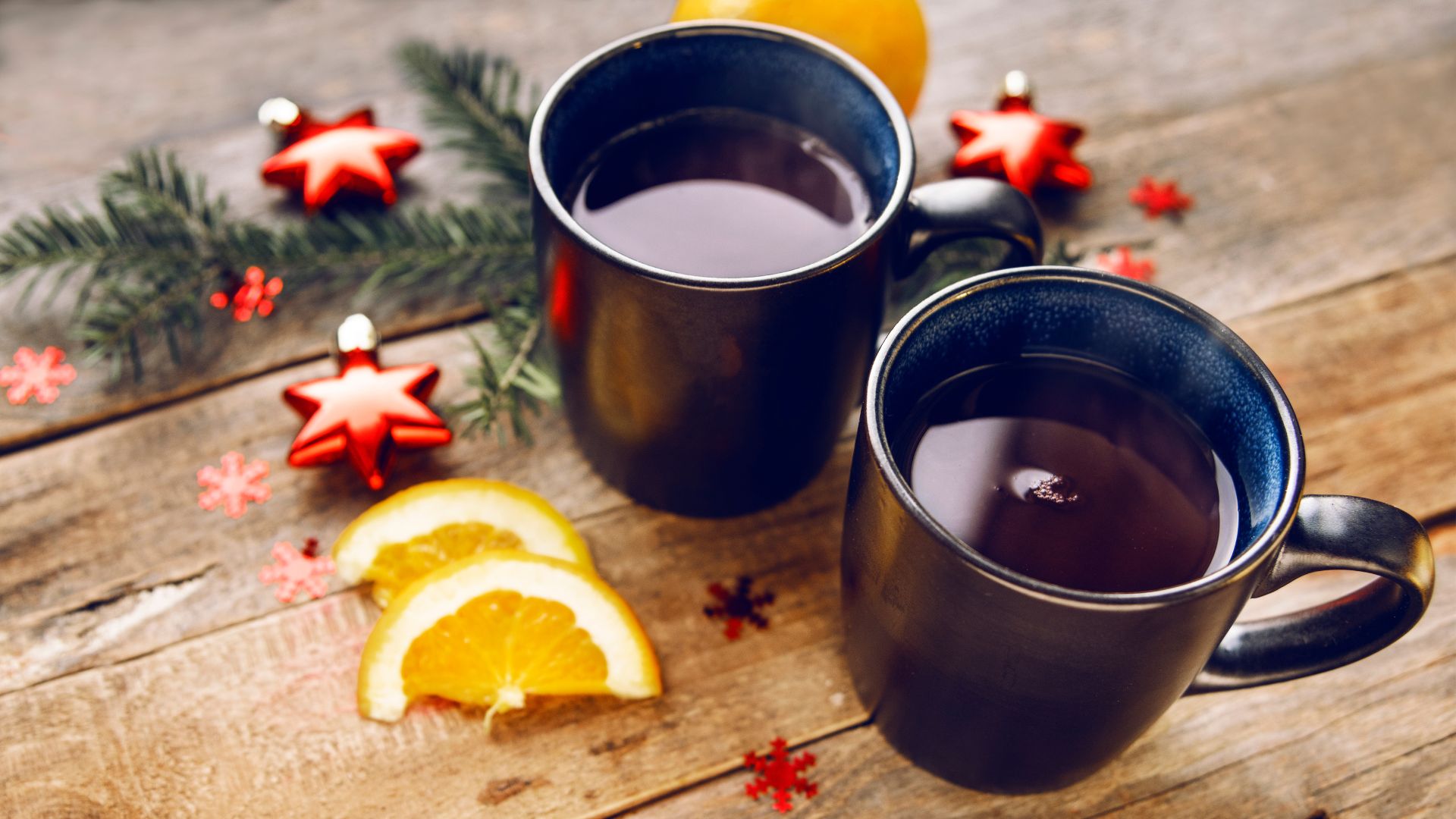 A high-angle shot shows 2 mugs of dark red mulled wine: Glühwein.
