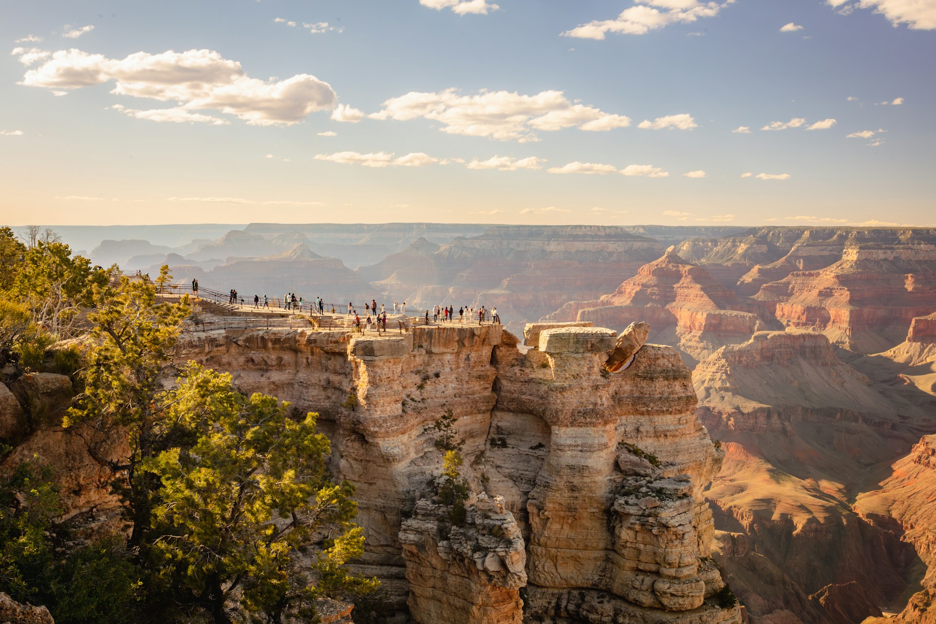 Tourists stand at a scenic overlook on the edge of the Grand Canyon
