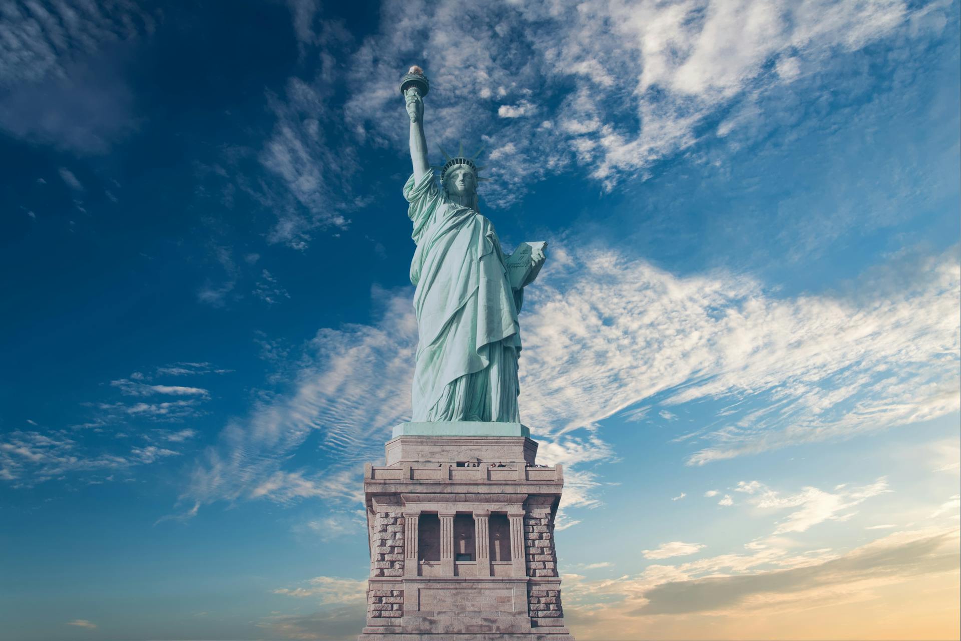 The Statue of Liberty standing tall on Liberty Island against a clear blue sky