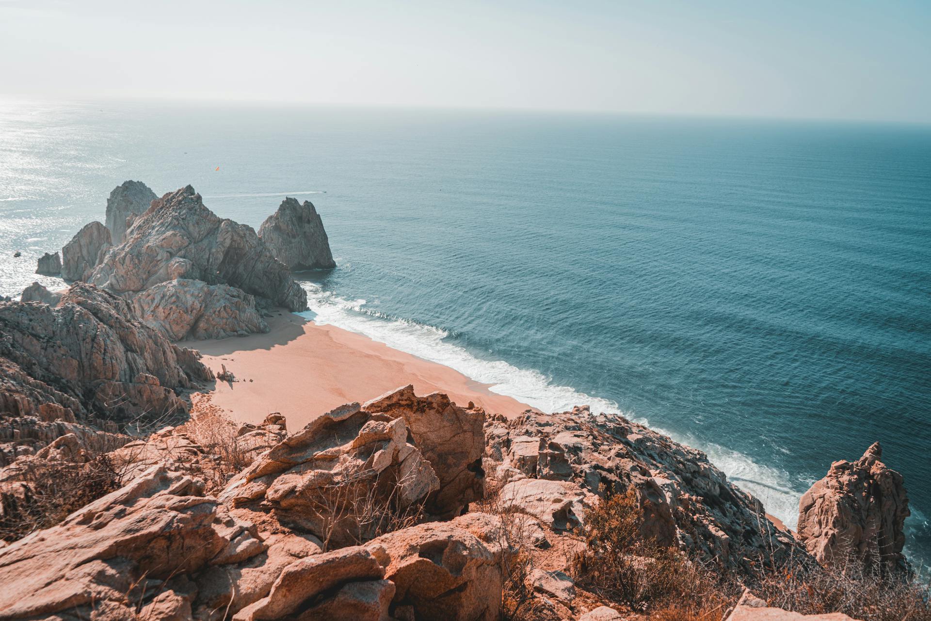 Serene beach in Los Cabos with golden sand, clear turquoise water, and gentle waves under a bright blue sky