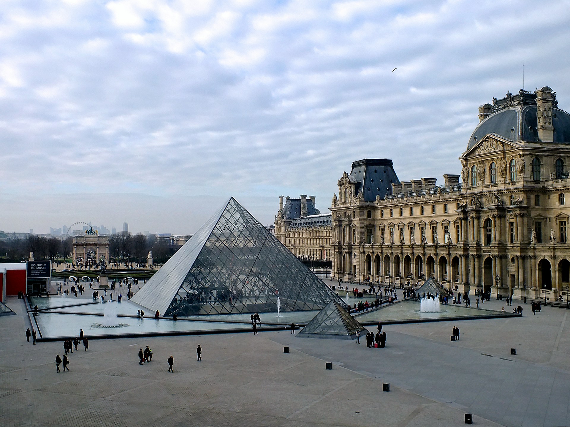 The Louvre Pyramid bathed in bright sunlight during the day
