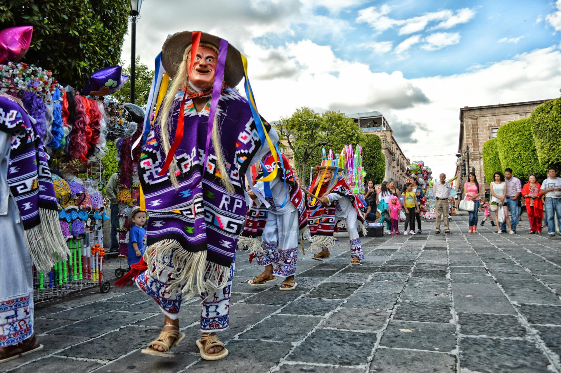 Colorful street festival in Mexico City featuring traditional costumes, dancers, and festive decorations