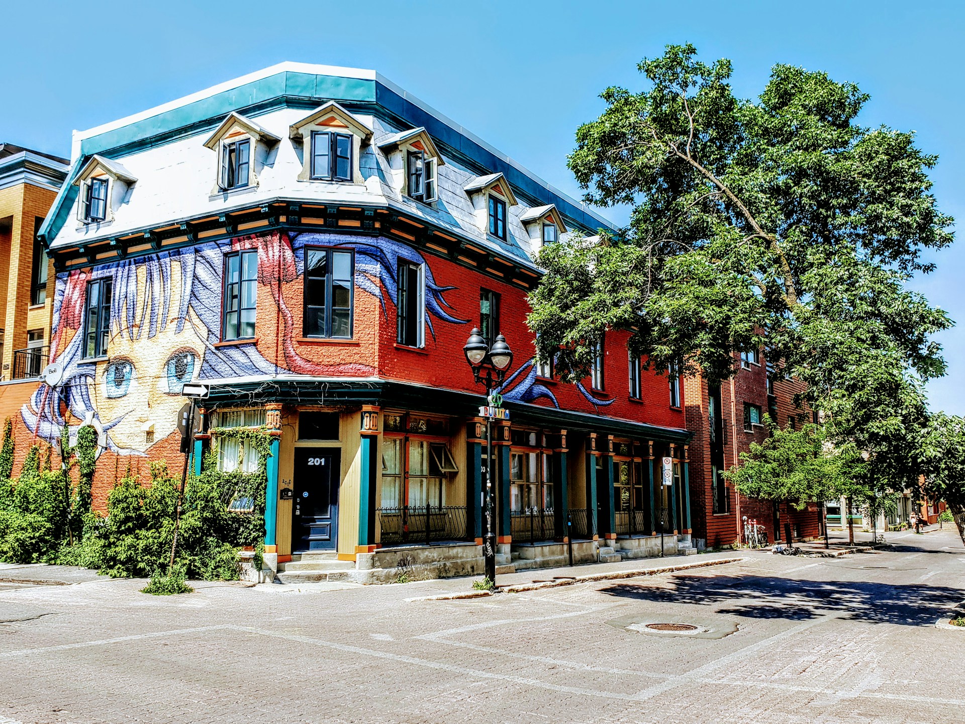 Montreal street view with low-rise buildings covered in colorful graffiti and murals