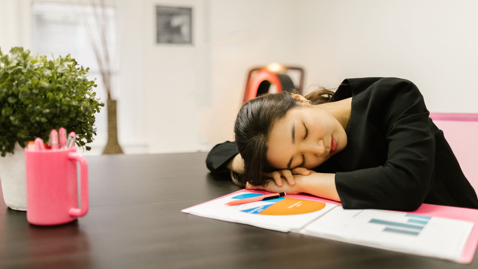 A woman napping at the office. 
