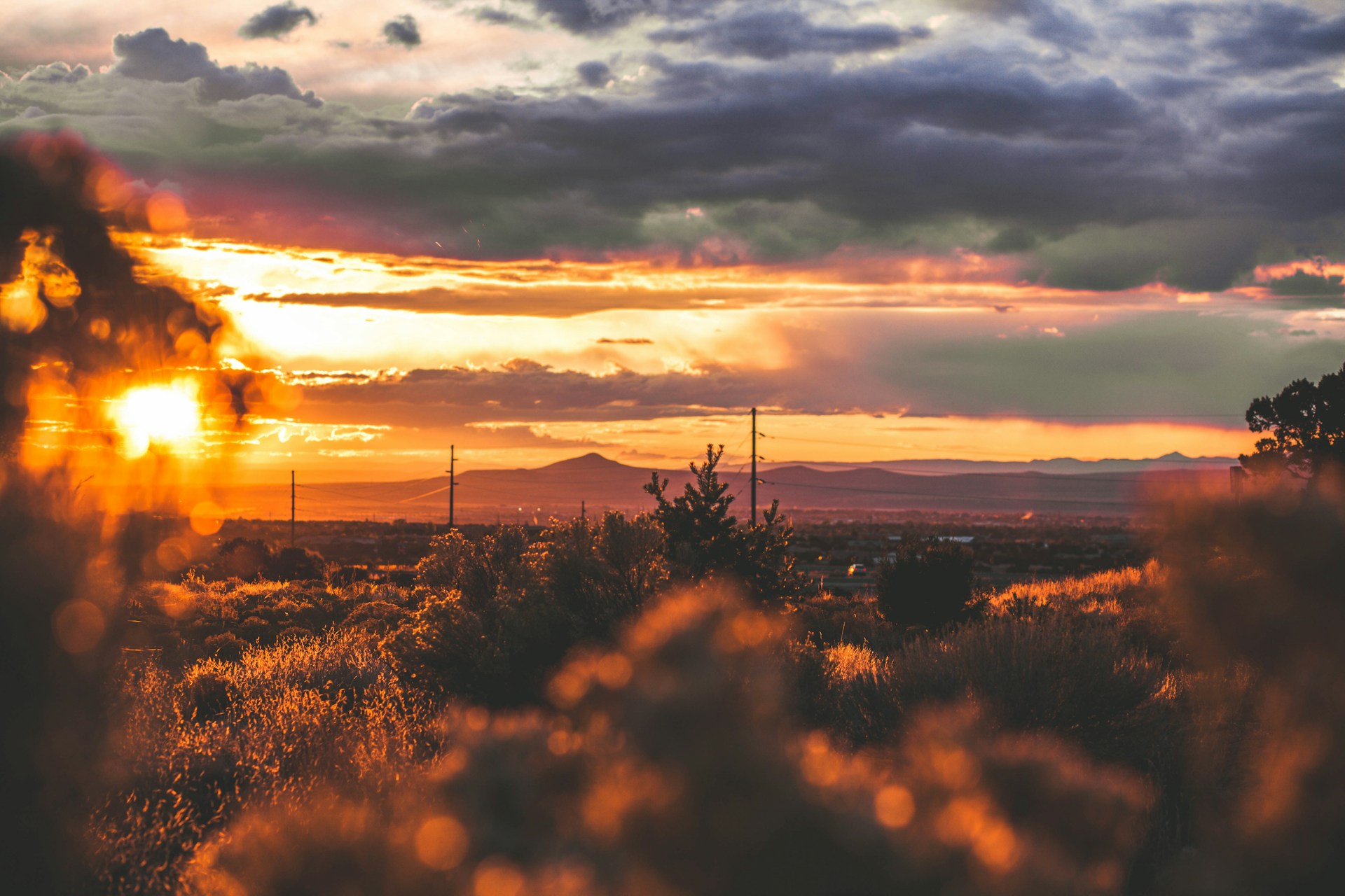 Vibrant New Mexico sunset with fiery orange and pink skies stretching over desert plains.