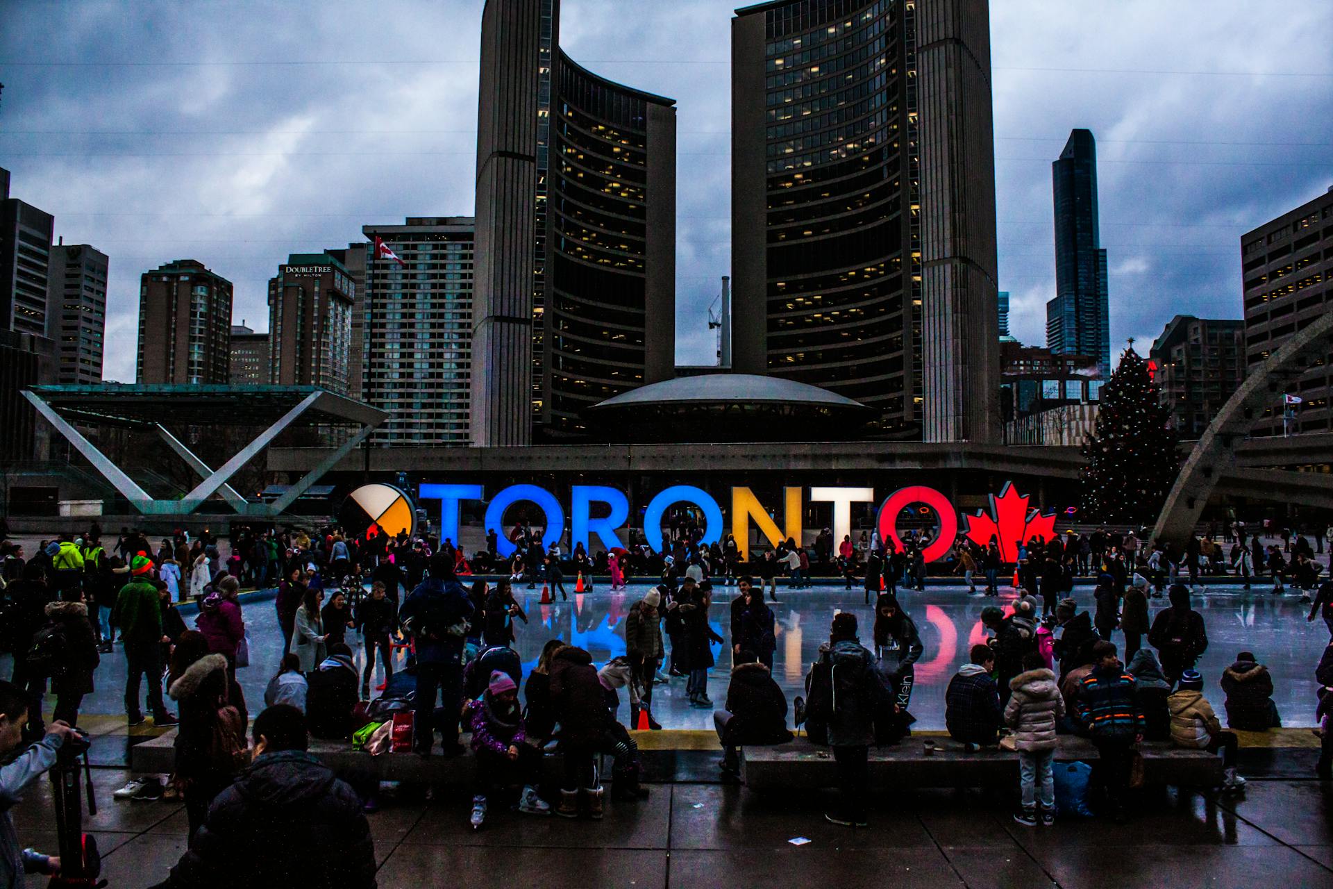 Large crowd gathered in downtown Toronto with bright city signage
