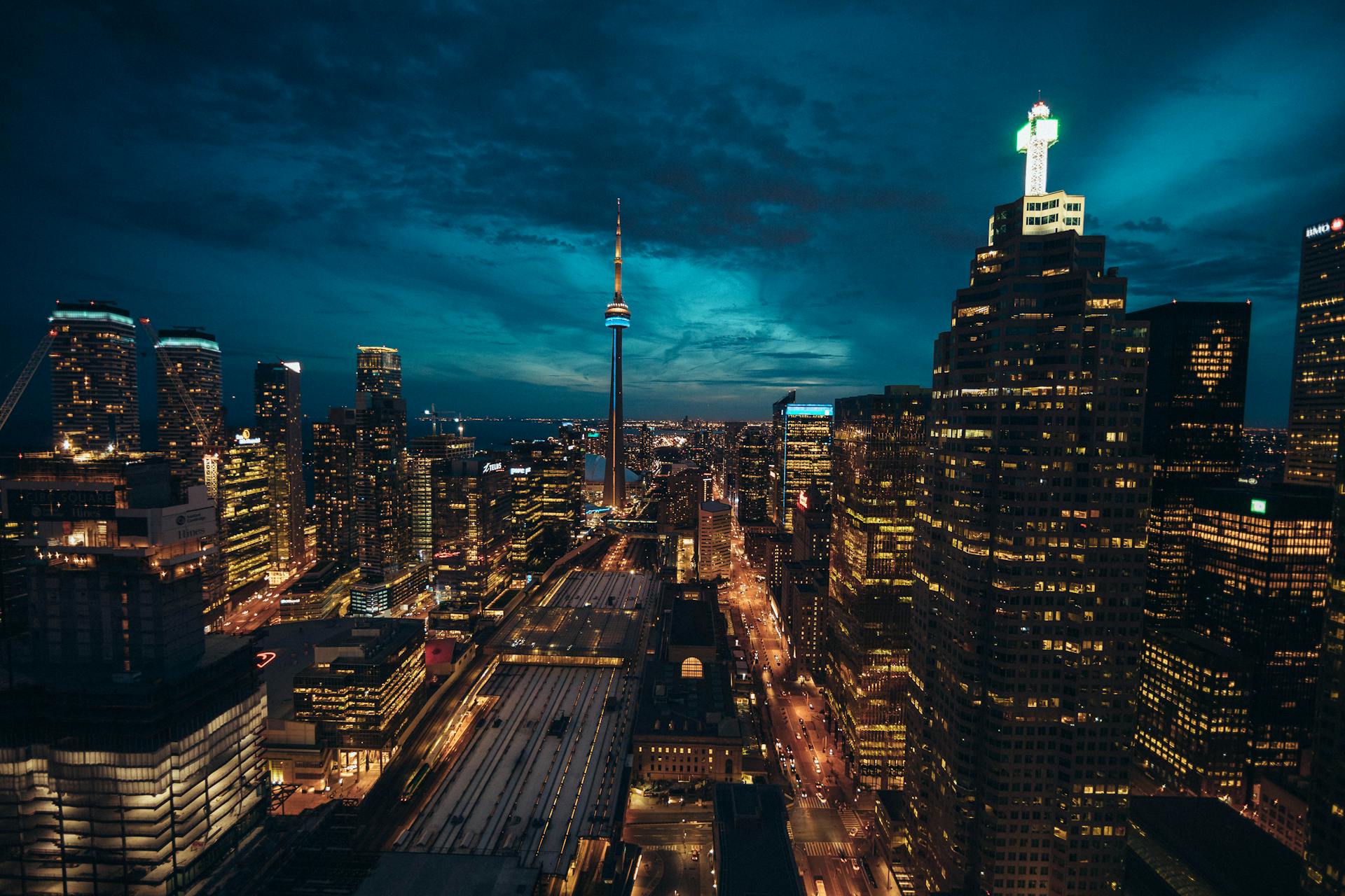 Toronto skyline at night with city lights illuminating the buildings and the CN Tower glowing in vibrant colors