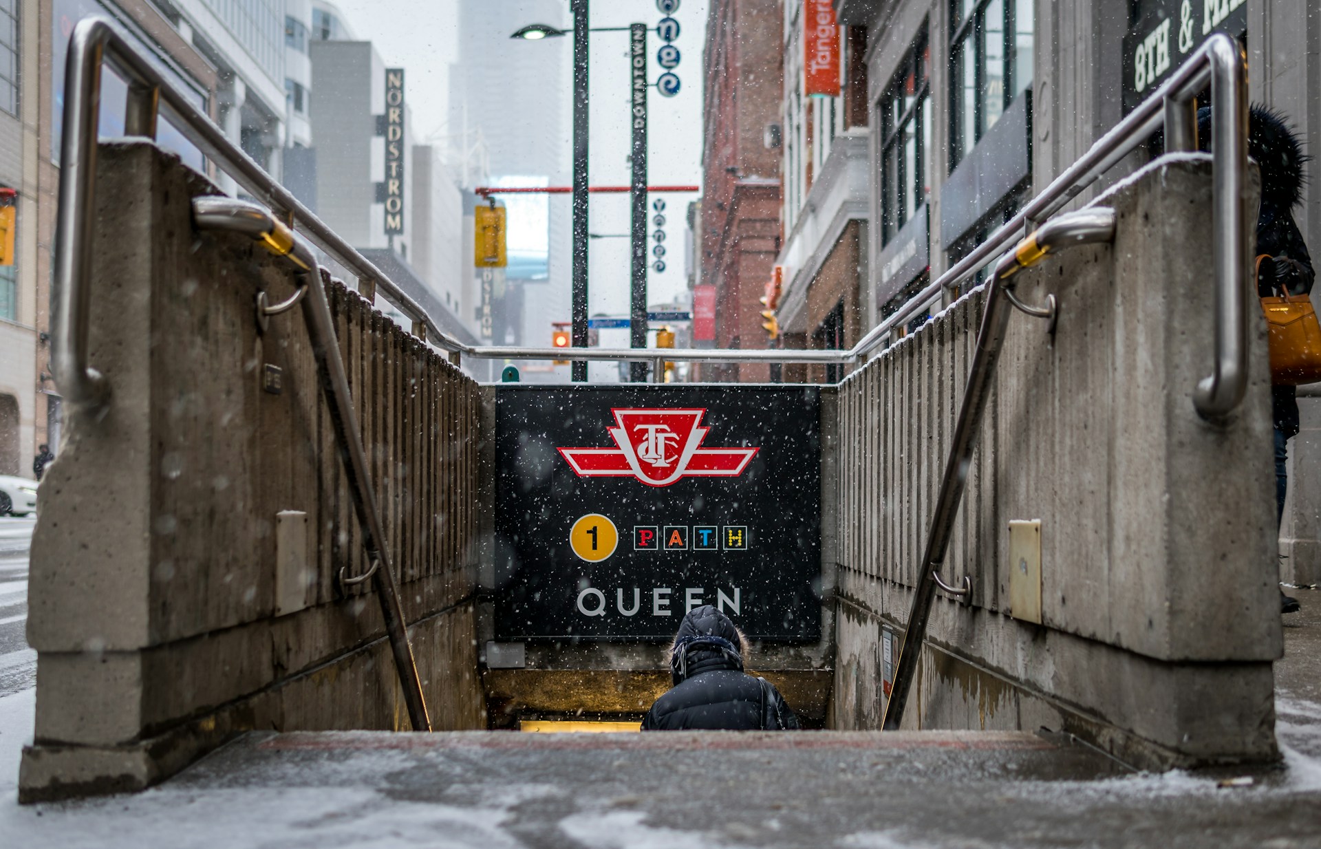 Snowy sidewalk leading to a Toronto subway entrance