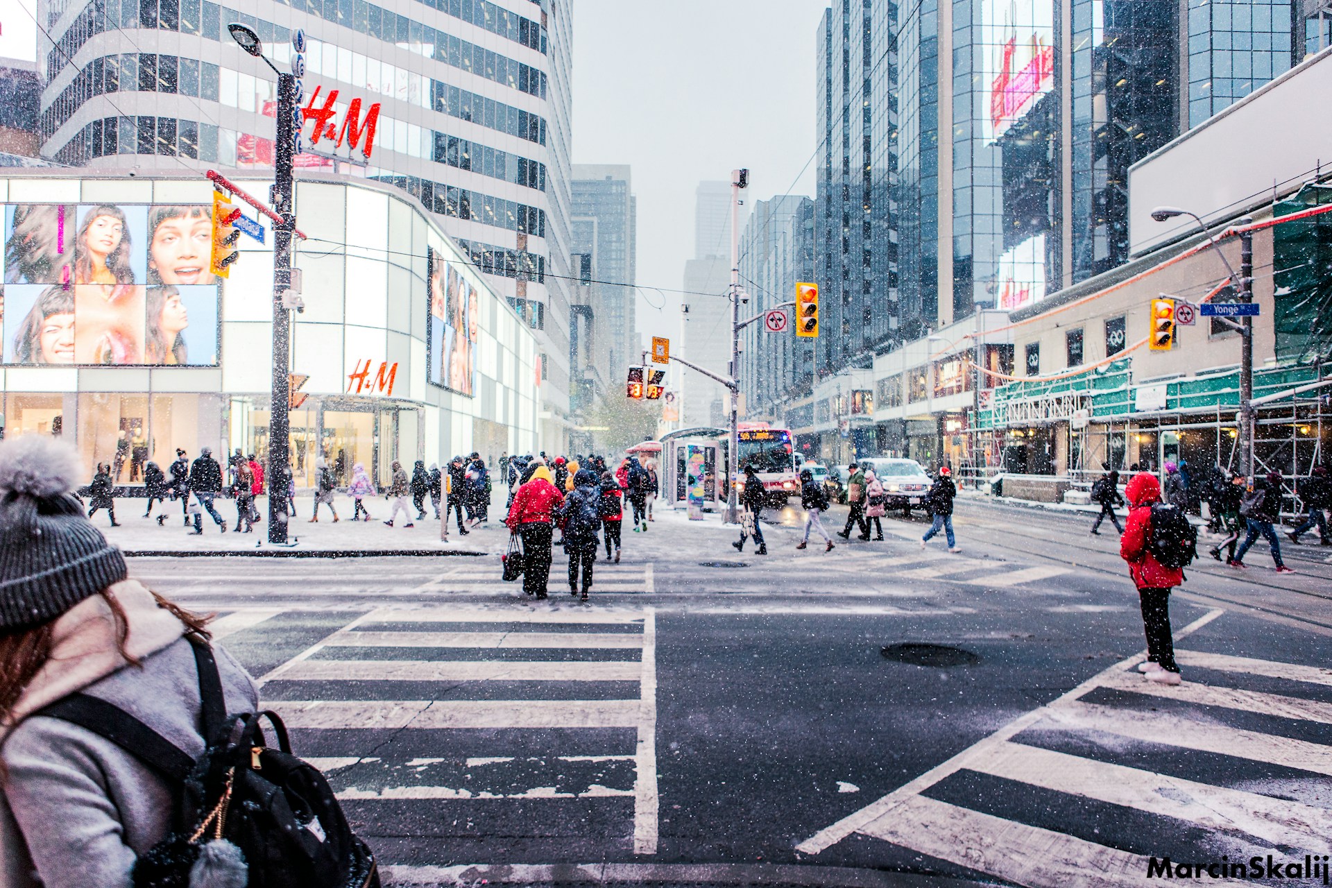 Snow-covered Toronto street bustling with cars and bundled-up pedestrians