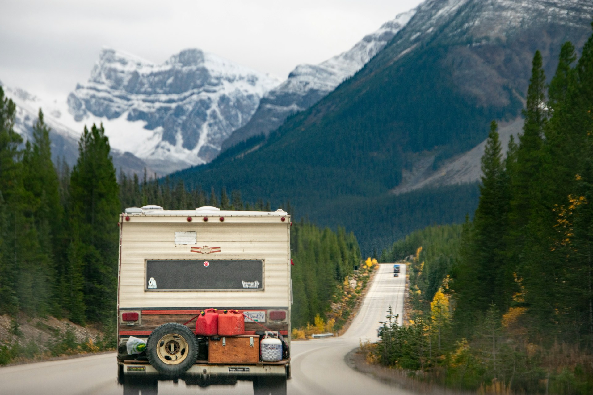 Long stretch of the Trans-Canada Highway cutting through vast Canadian wilderness beneath a dramatic sky.