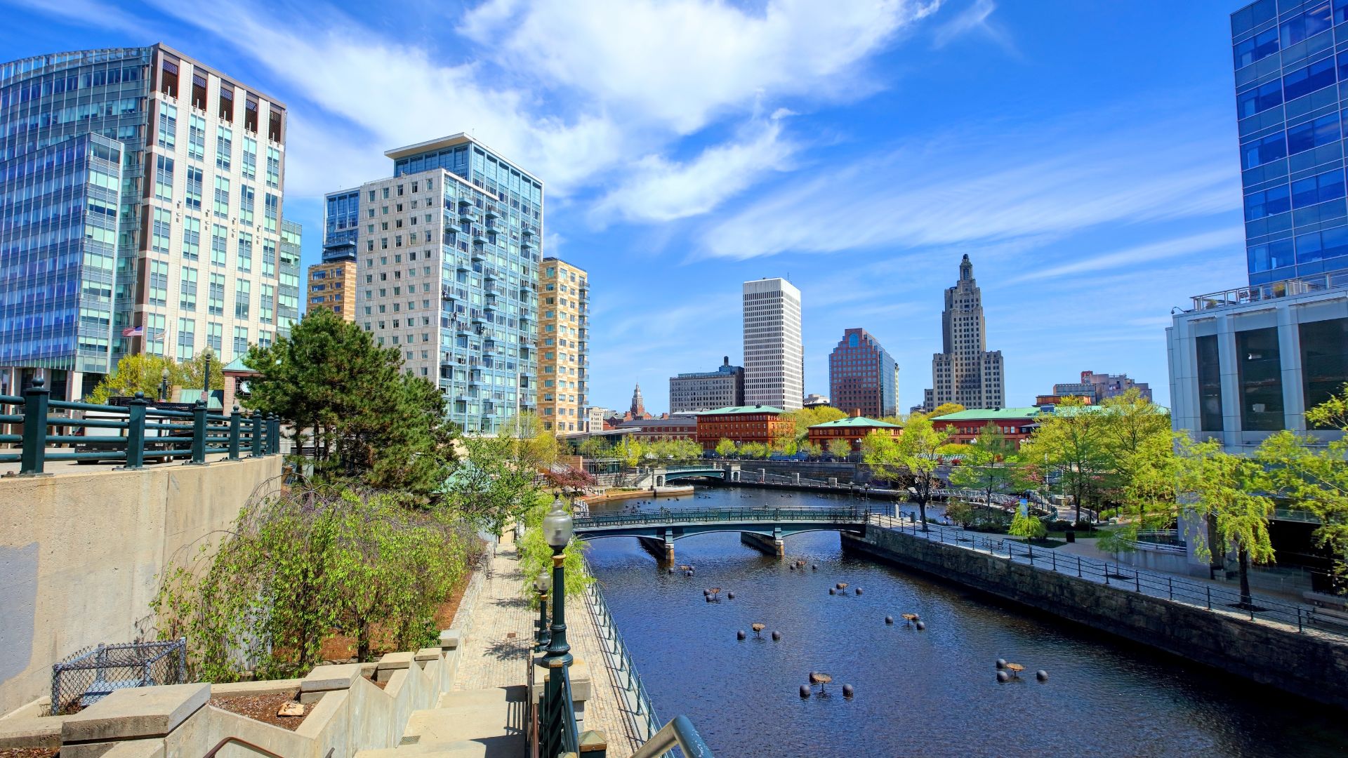 The image depicts Waterplace Park and the Providence River in Downtown Providence, Rhode Island, which is the setting for the WaterFire art installation. WaterFire is a renowned art installation and event that takes place on the Providence River, featuring bonfires and music.