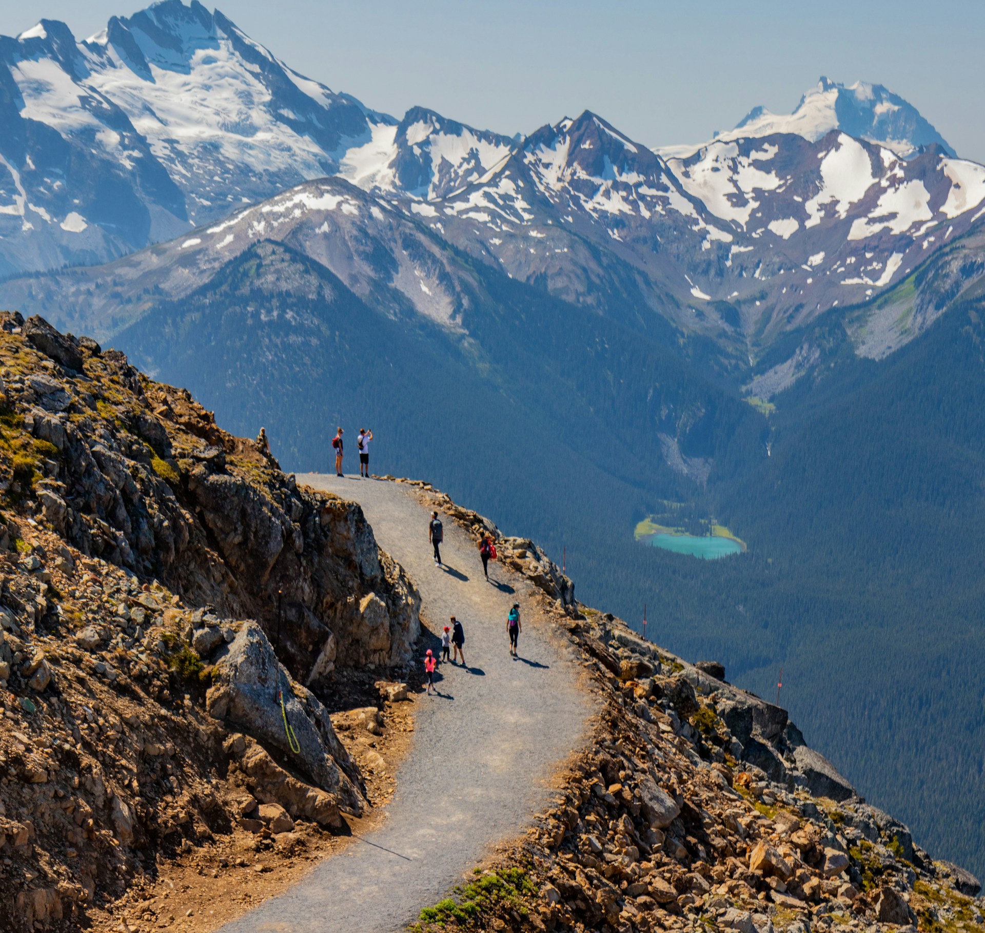 Hiker walking along a mountain trail in Whistler on a sunny day