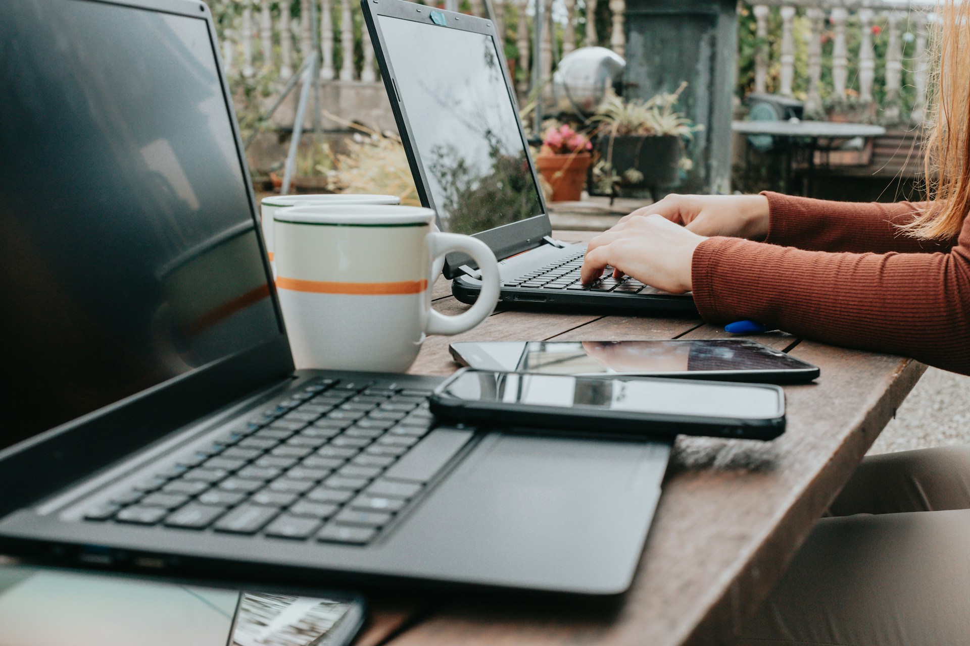 Freelancer working on a laptop from a sunny rooftop café in Mexico