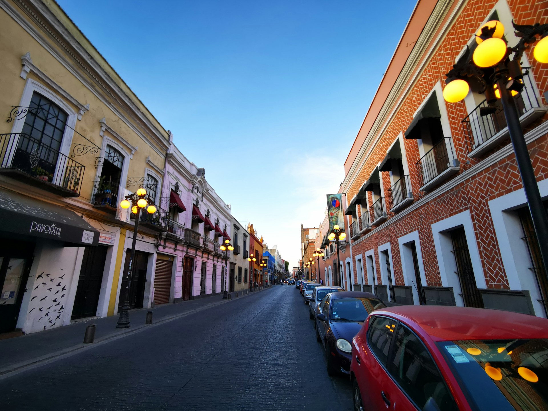 Colorful colonial buildings lining a historic cobblestone street in Puebla