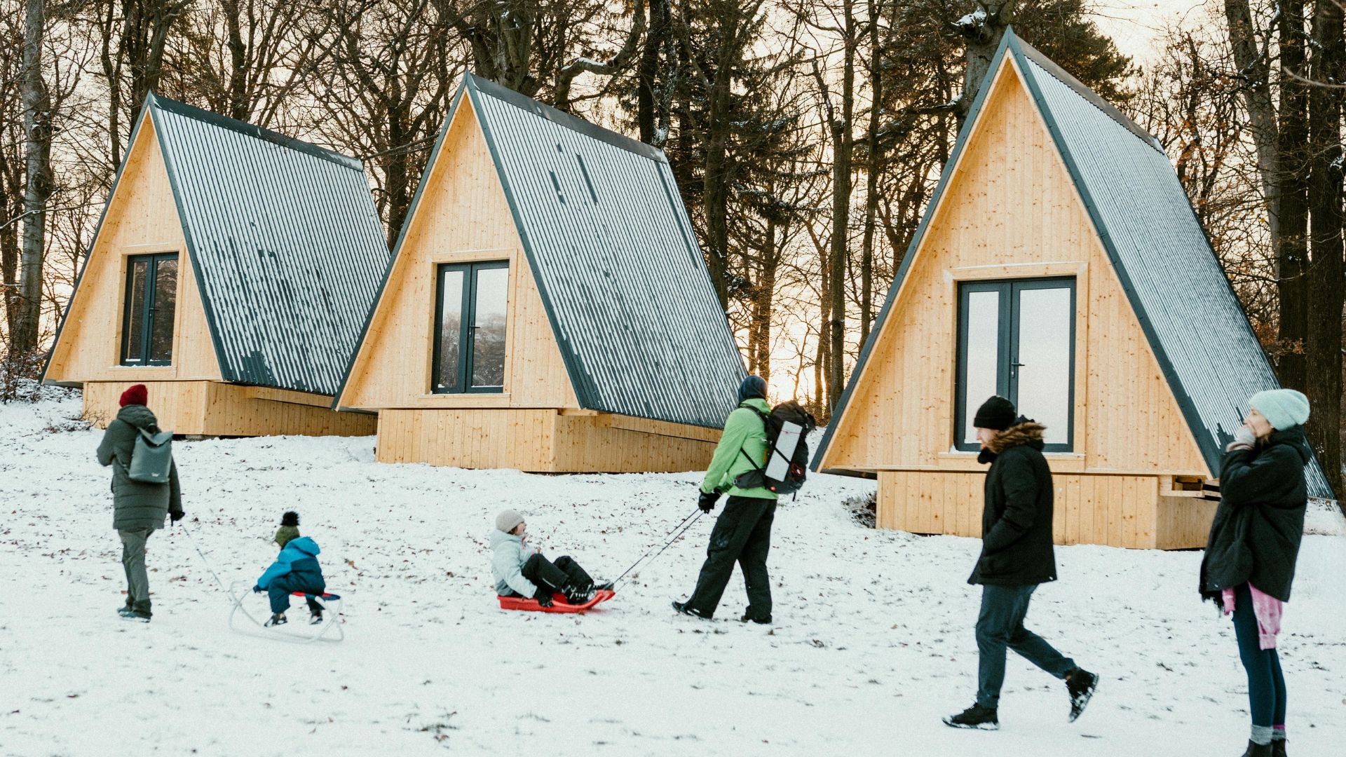 Cozy cabin (A-Frame cabin) and people in the snow.