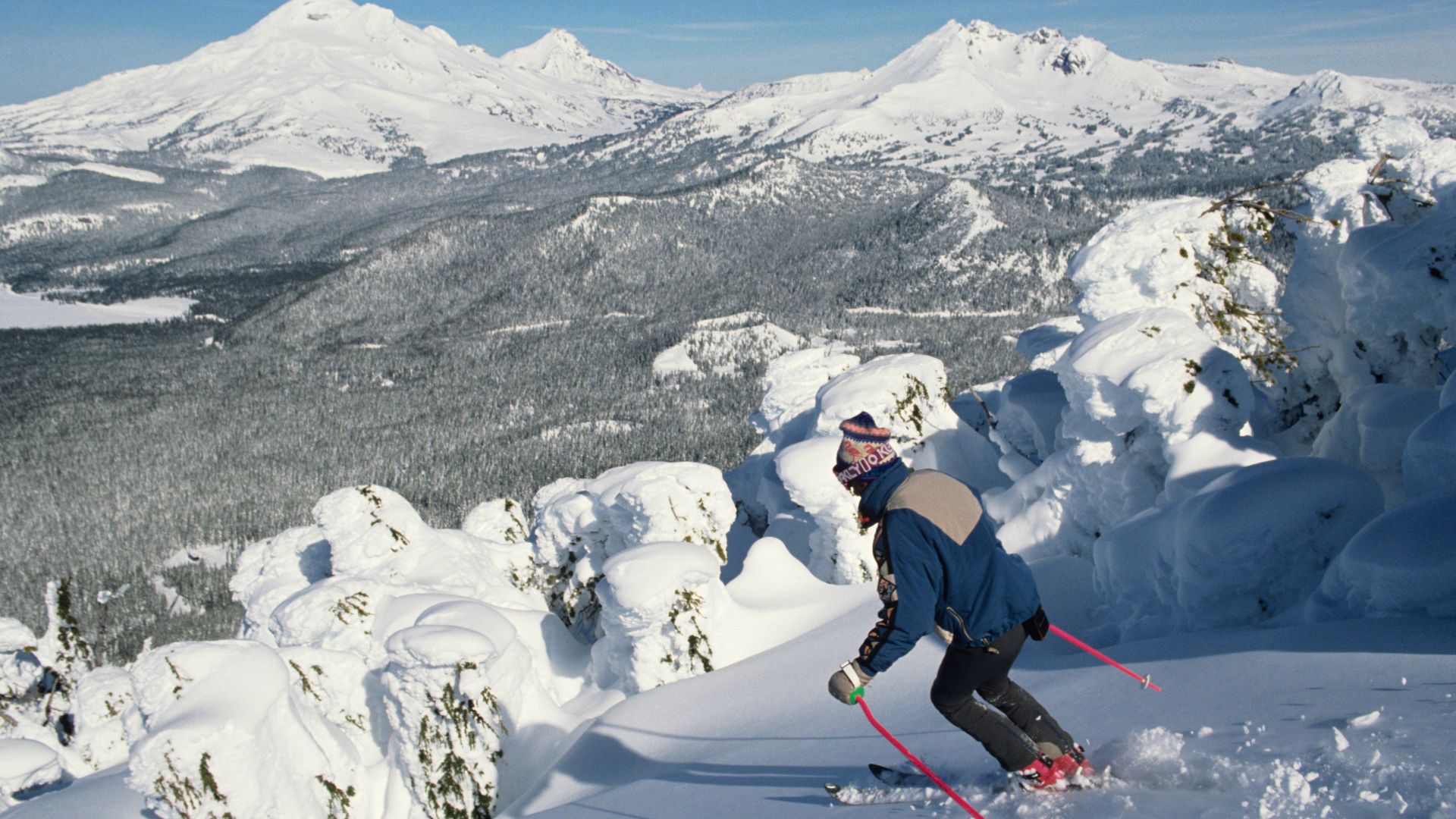 The image shows a skier enjoying the slopes at Mount Bachelor ski resort in Oregon